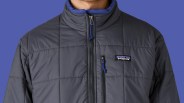 A male model shown from the neck down to mid torso wearing a Patagonia Light Gust Jacket in grey.