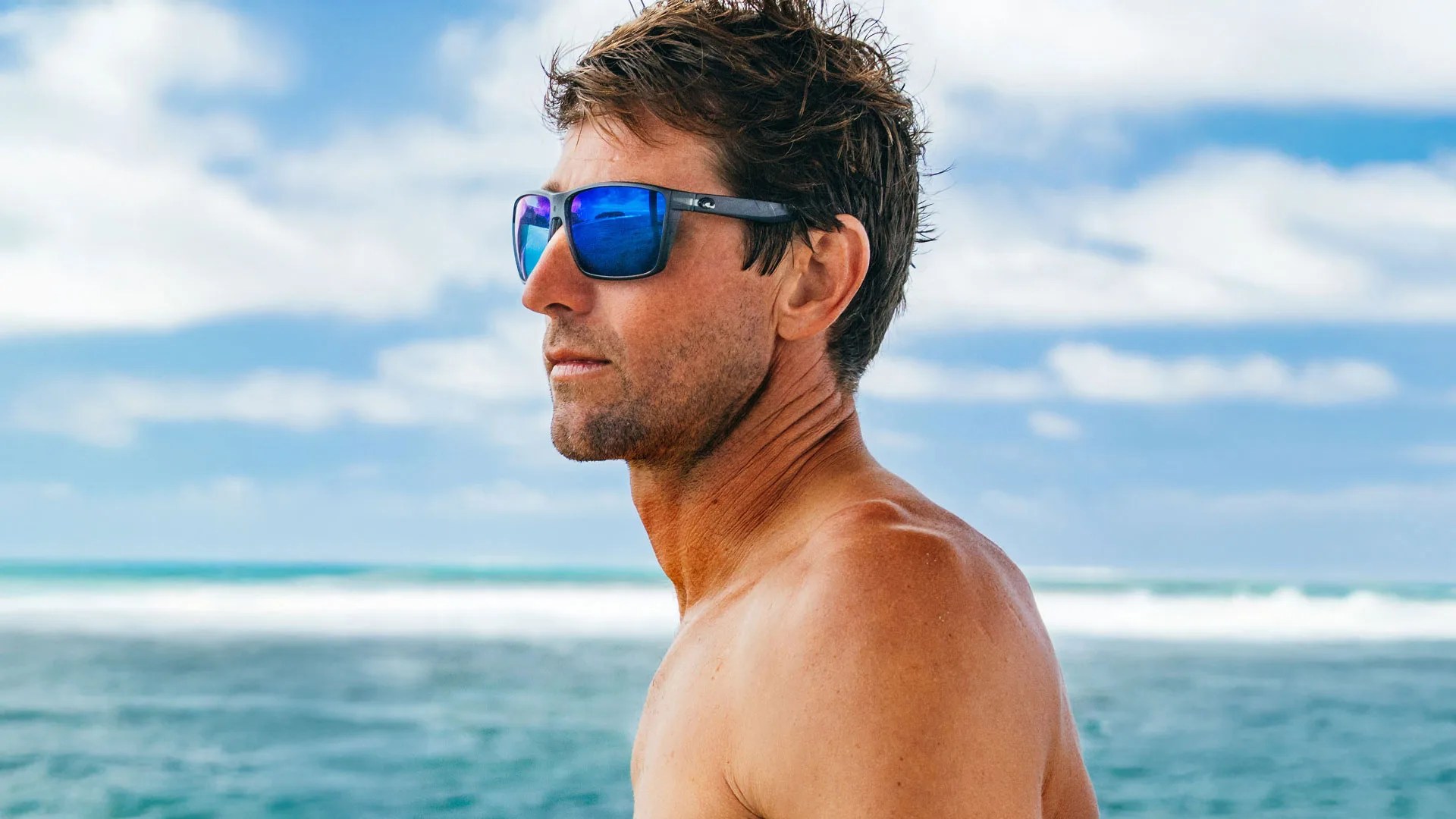 man wearing costa sunglasses by the ocean