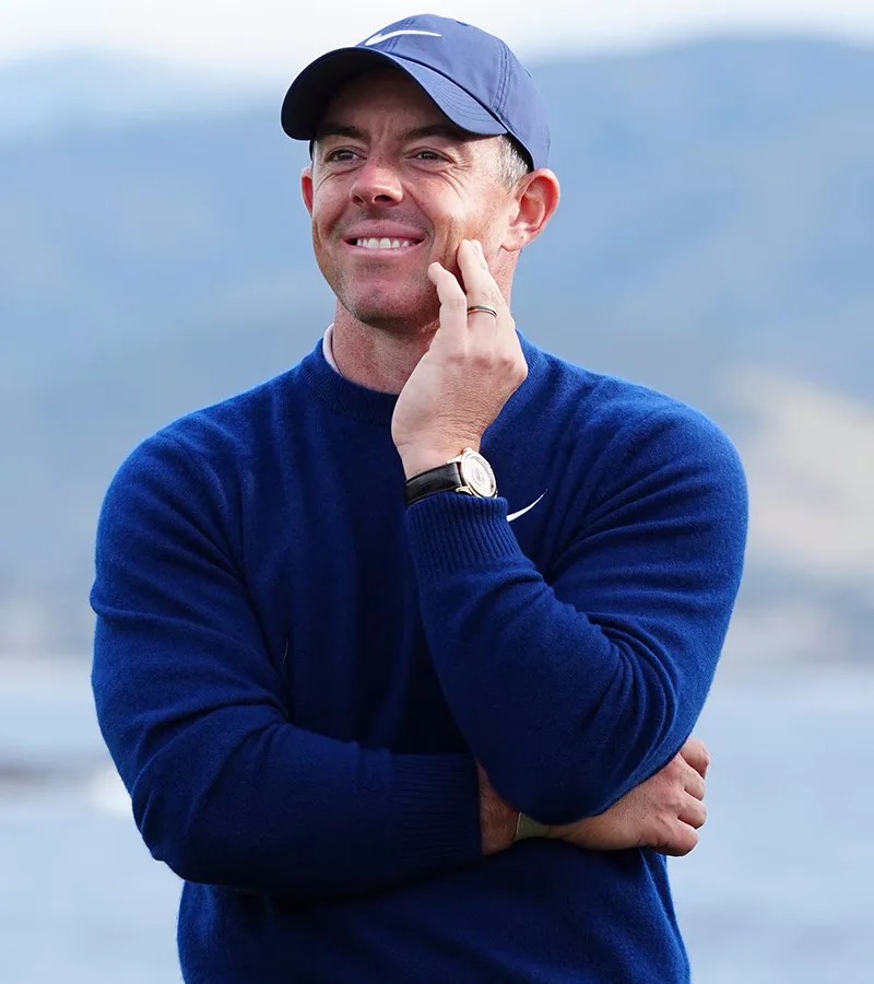 A portrait of Rory McIlroy wearing a blue sweater, blue Nike hat and Omega De Ville Tourbillion at the 2025 AT&T Pebble Beach Pro-Am tournament.