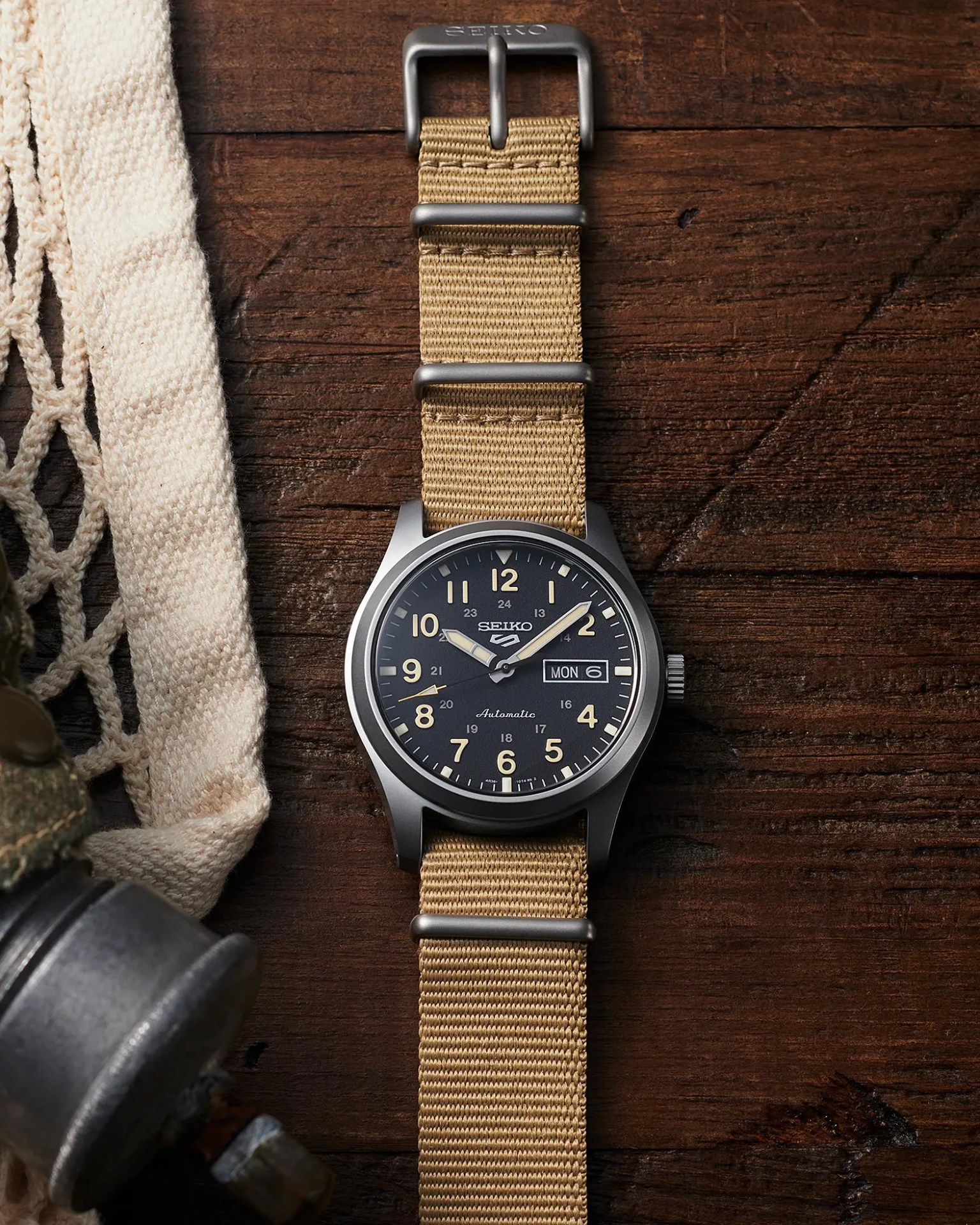 a seiko 5 sports field watch laying on a desk