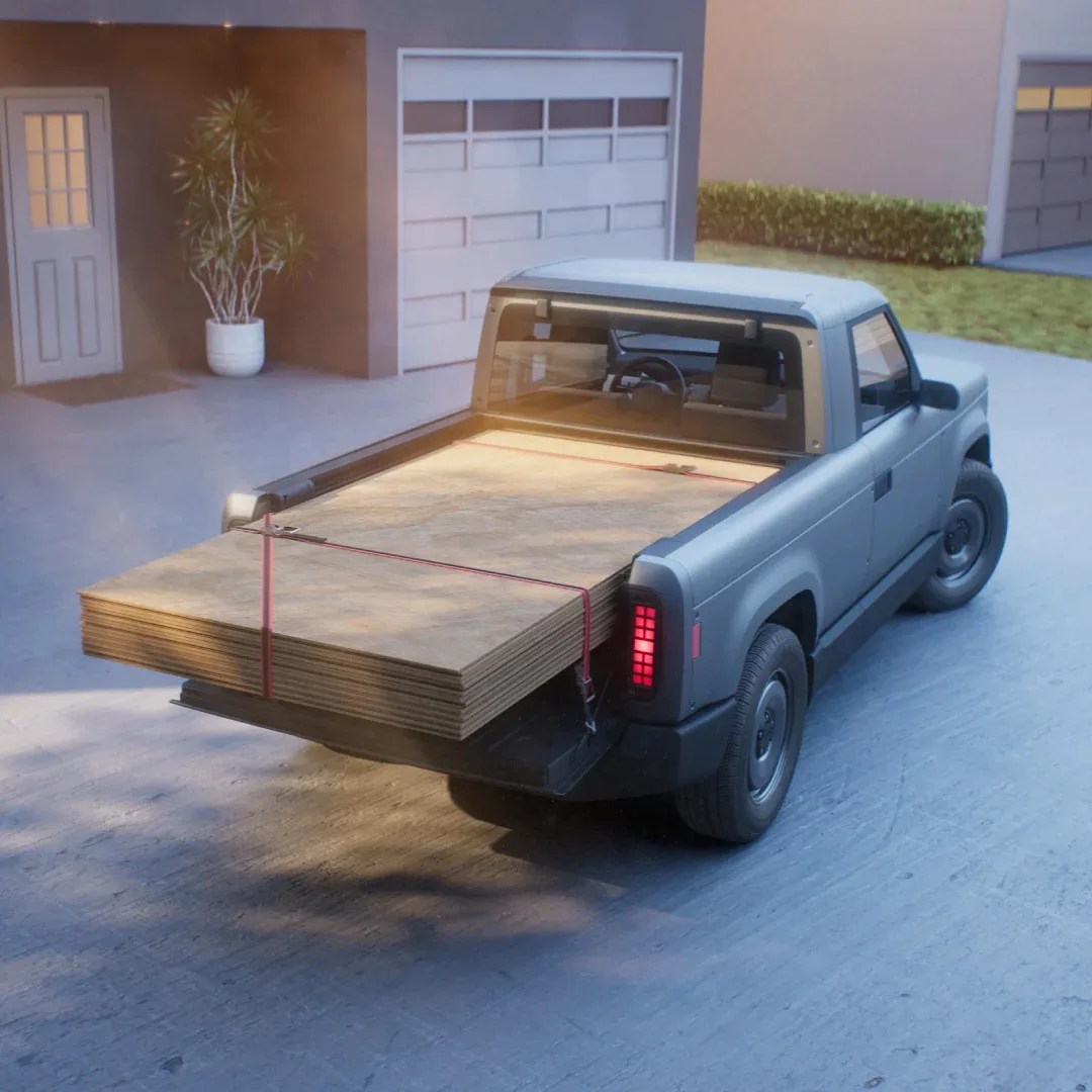 The Slate Auto Blank Slate EV Truck shown carrying plywood in the bed. 