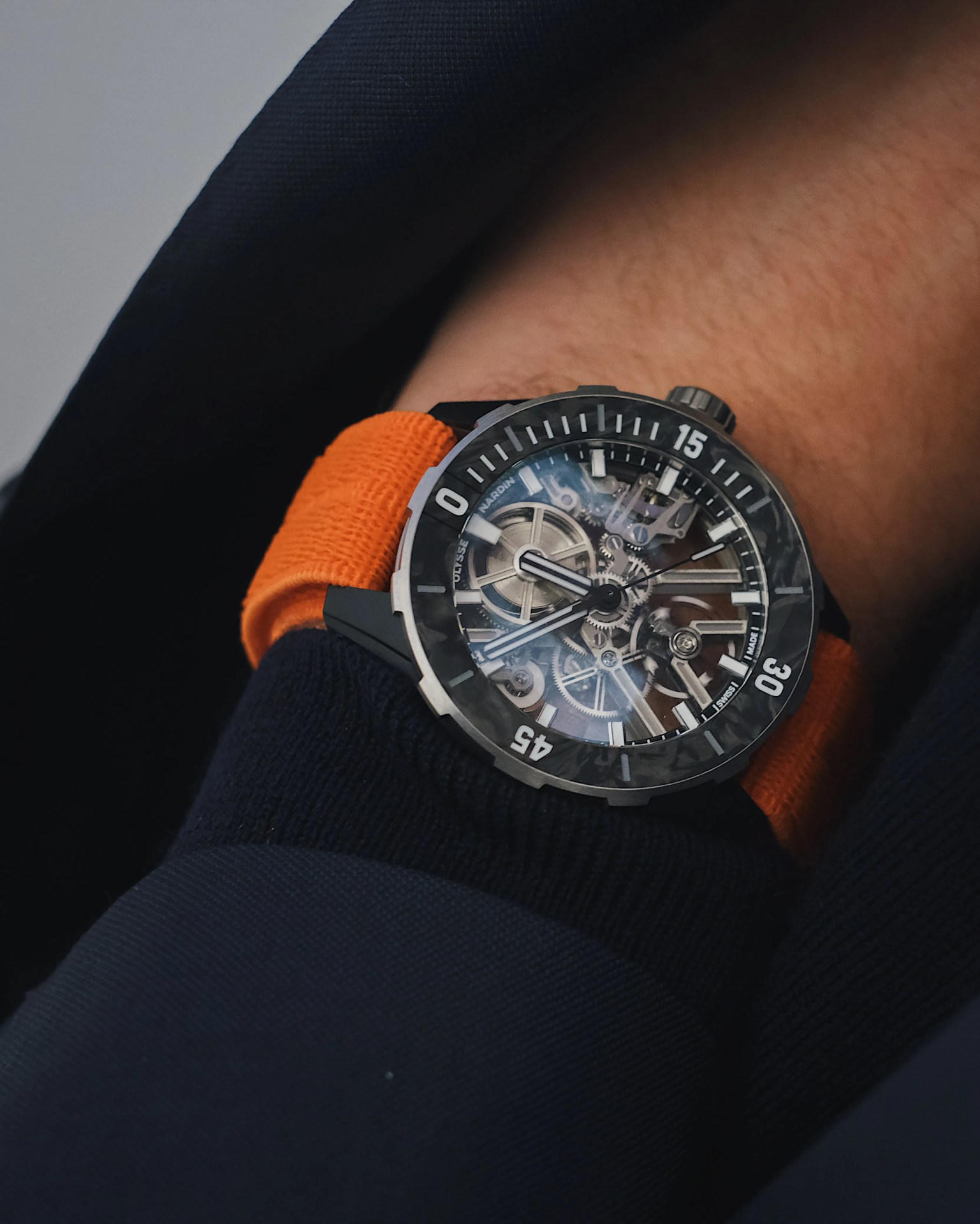 Ulysses Nardin Diver Air watch shown on man’s wrist reaching into a blazer pocket
