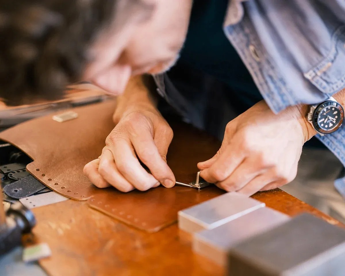 a man assembling a leather bag