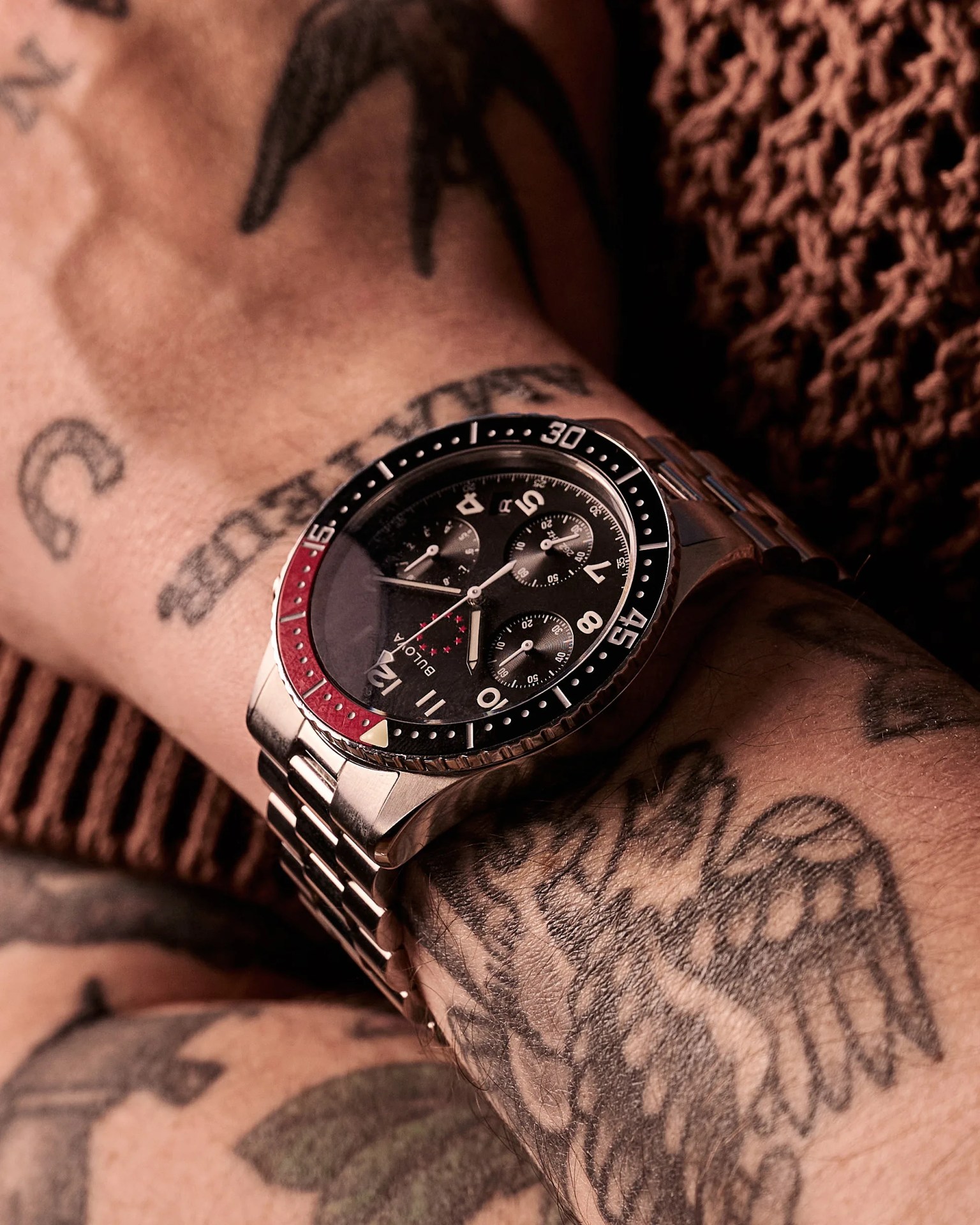 a black dial chronograph watch on a man's wrist
