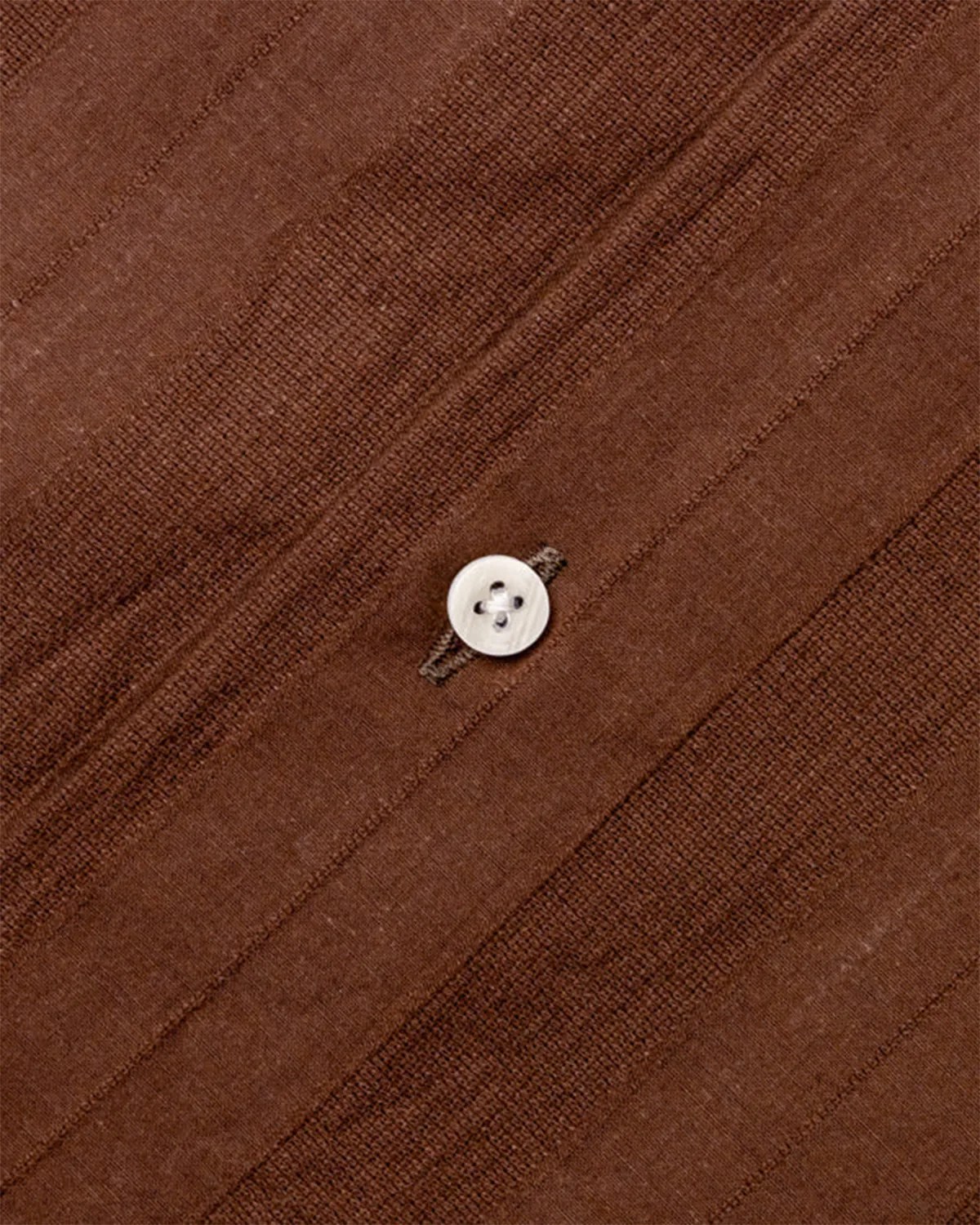 the button and placket of a brown shirt