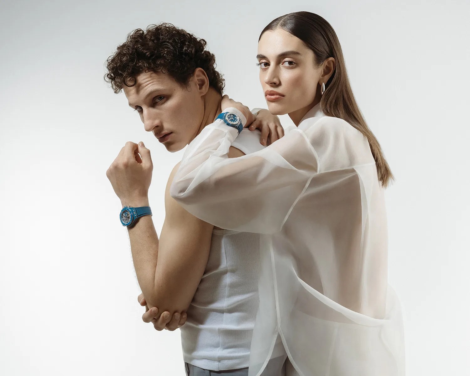 a man and woman wearing hublot watches