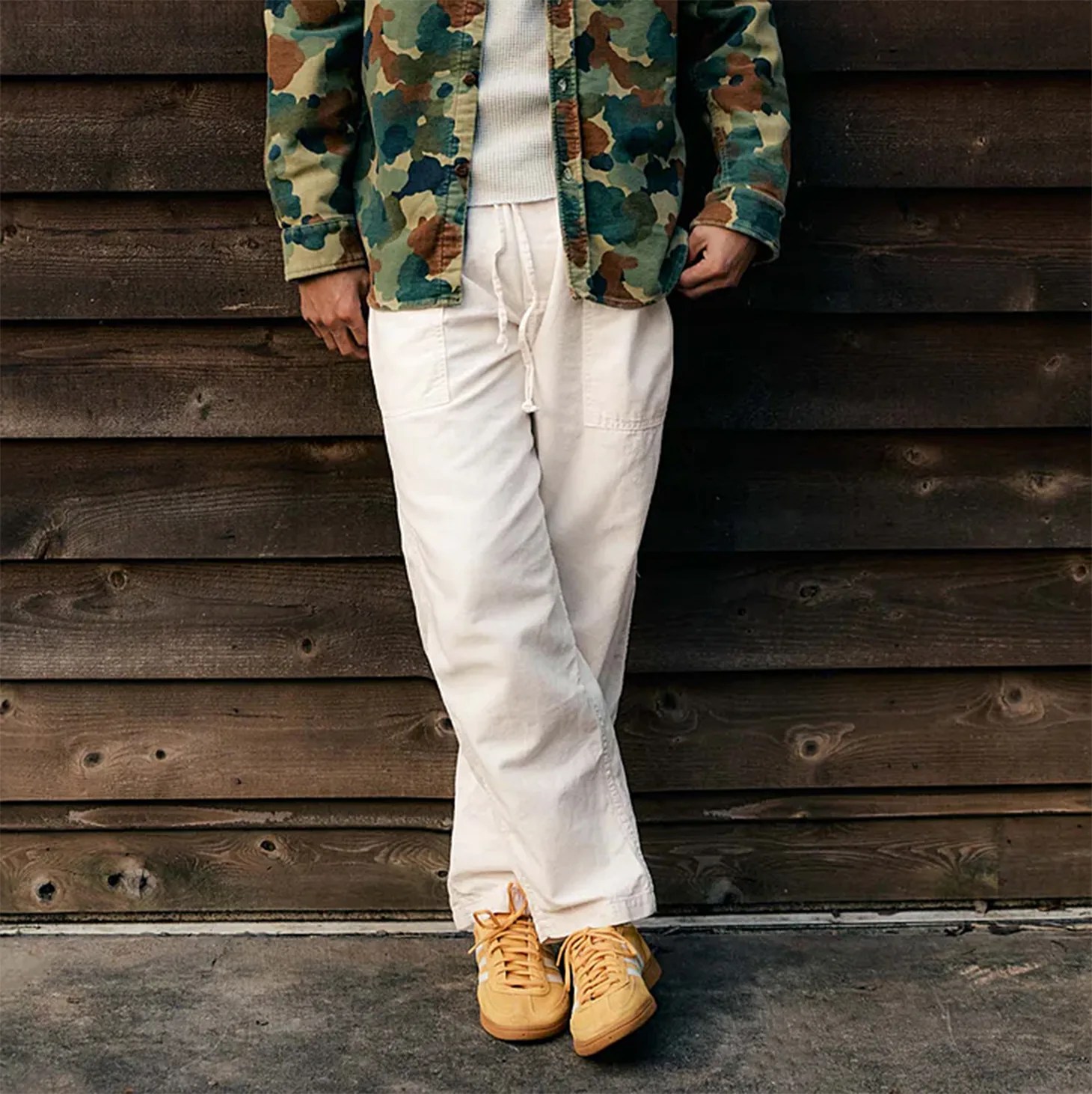 a man wearing white pants and a como jacket