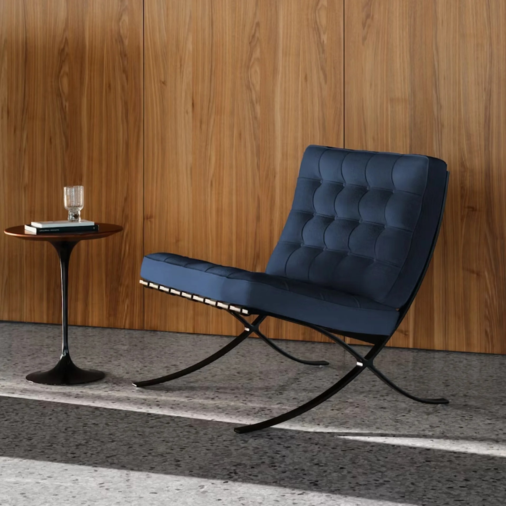 a knoll barcelona chair in a wood paneled room