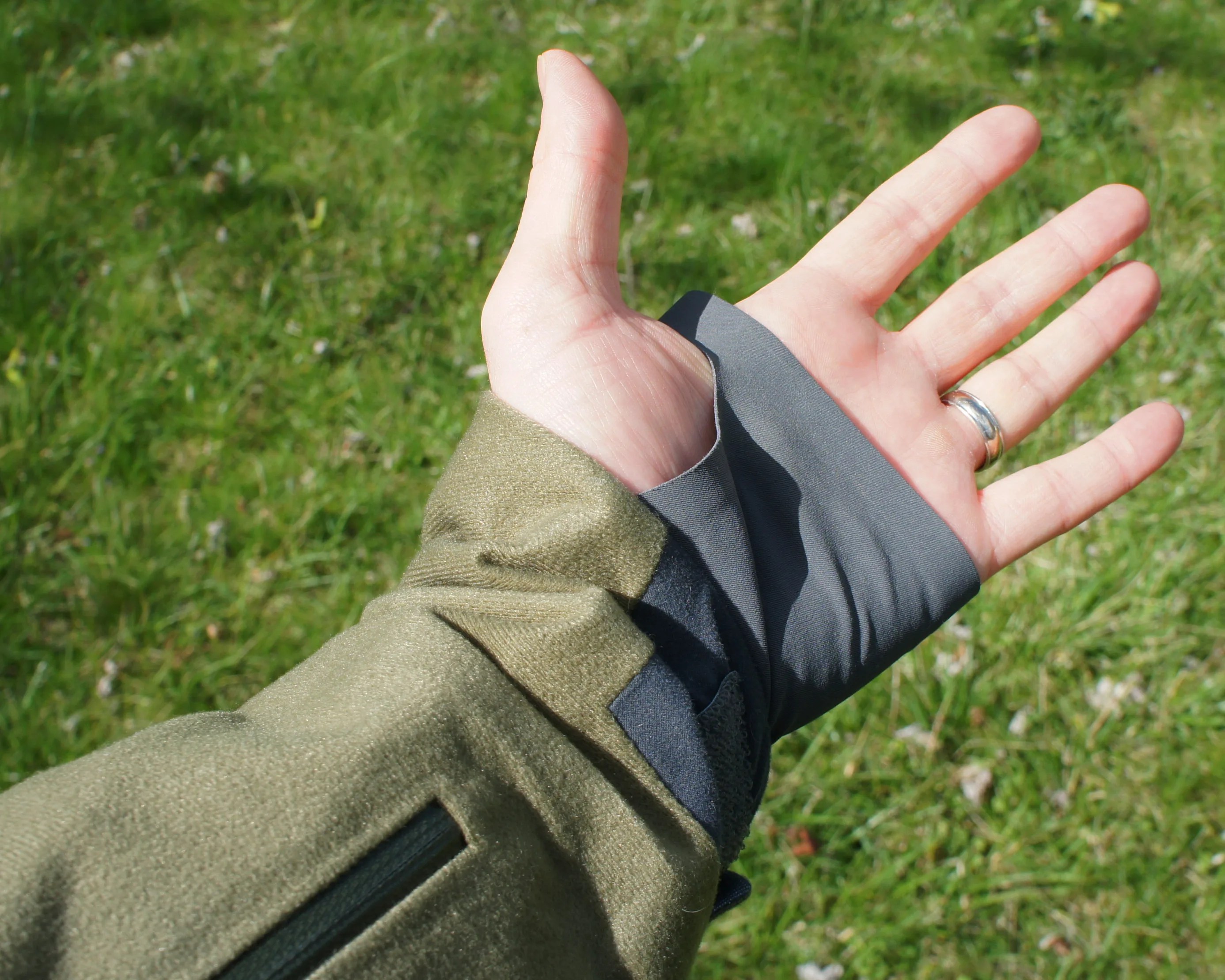a man's wrist with a green jacket sleeve