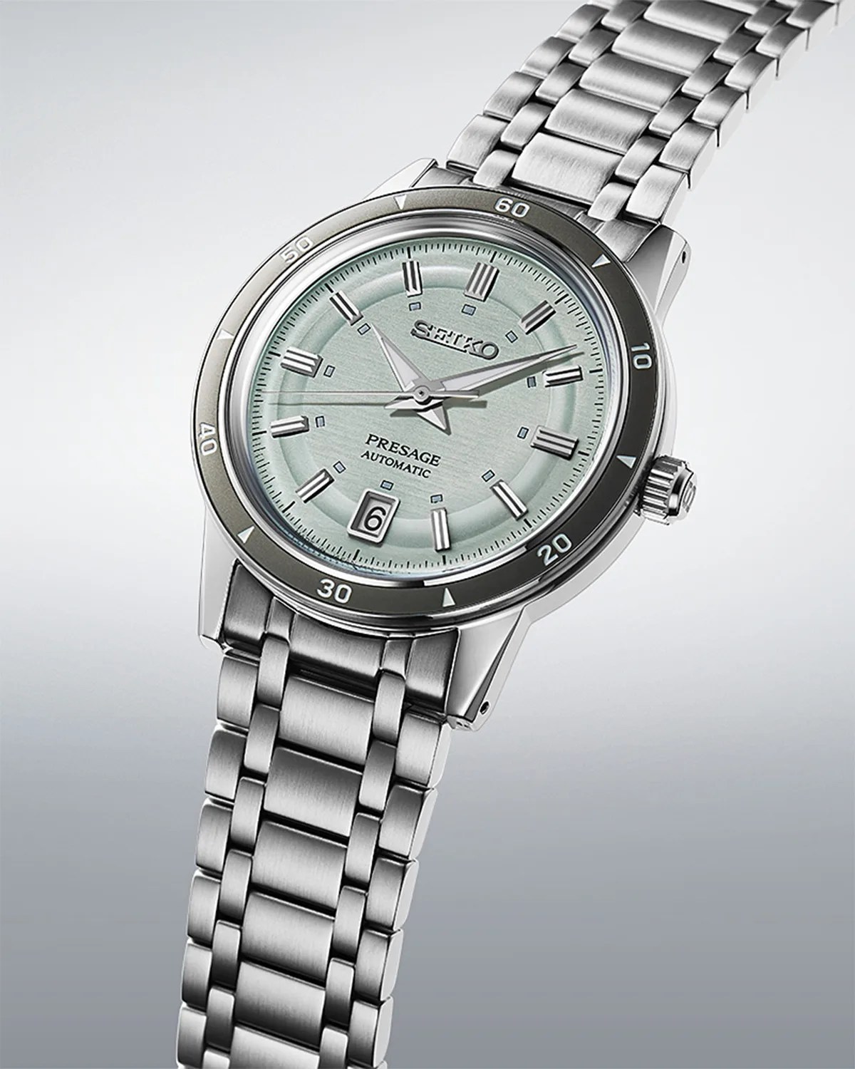 a Seiko watch with a steel bracelet and green dial
