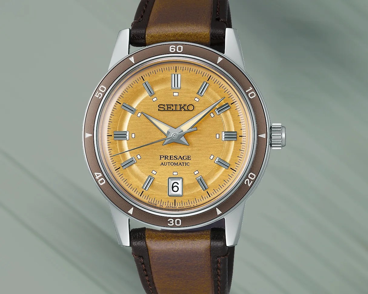 a watch with a yellow dial and brown leather strap