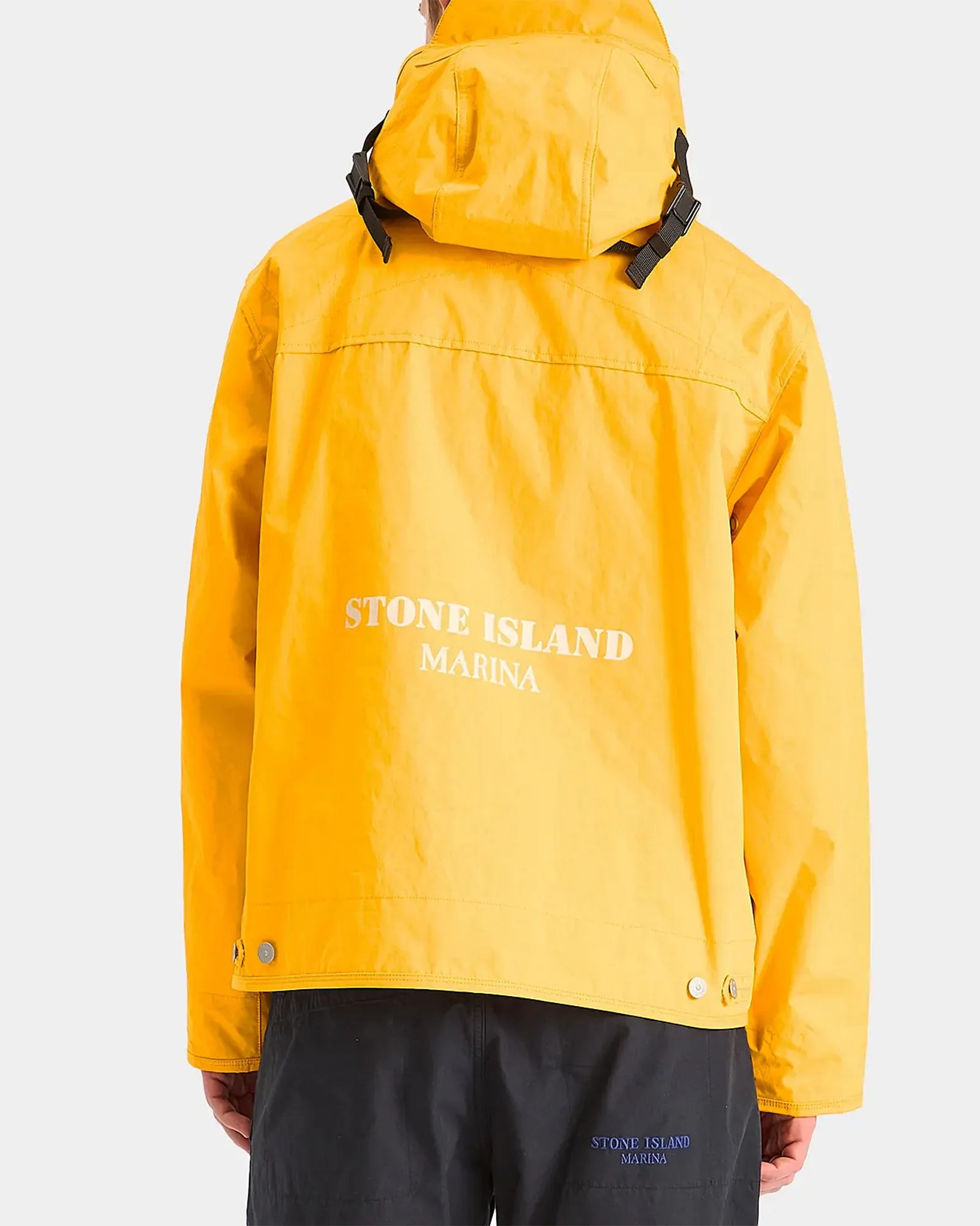 the back of a man wearing a yellow raincoat that says Stone Island Marina on it