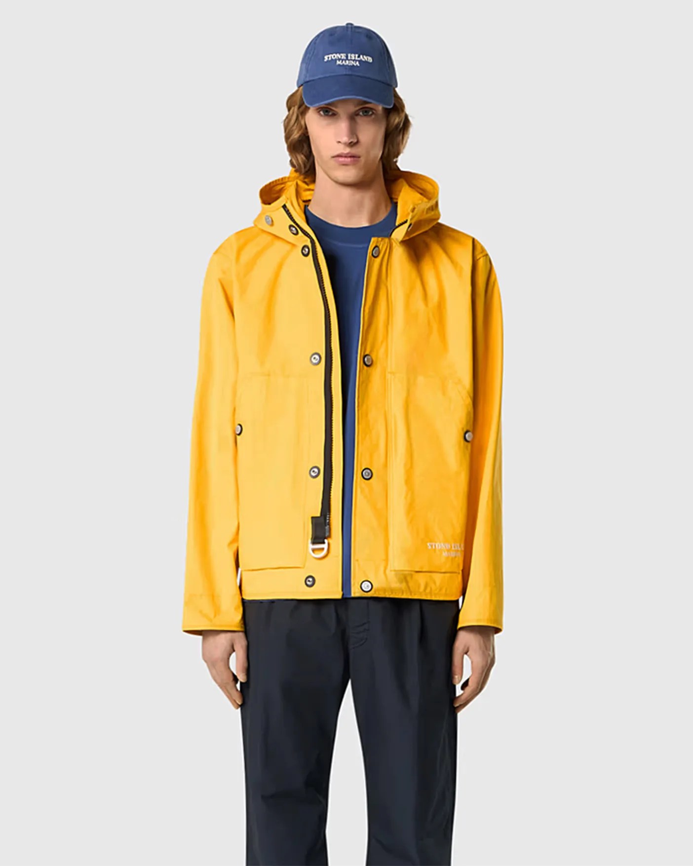 a man in a yellow raincoat, blue hat and navy pants