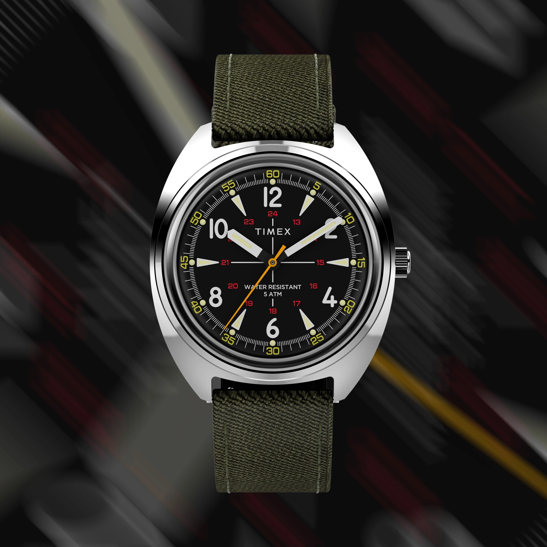 a field watch with a black dial and green strap