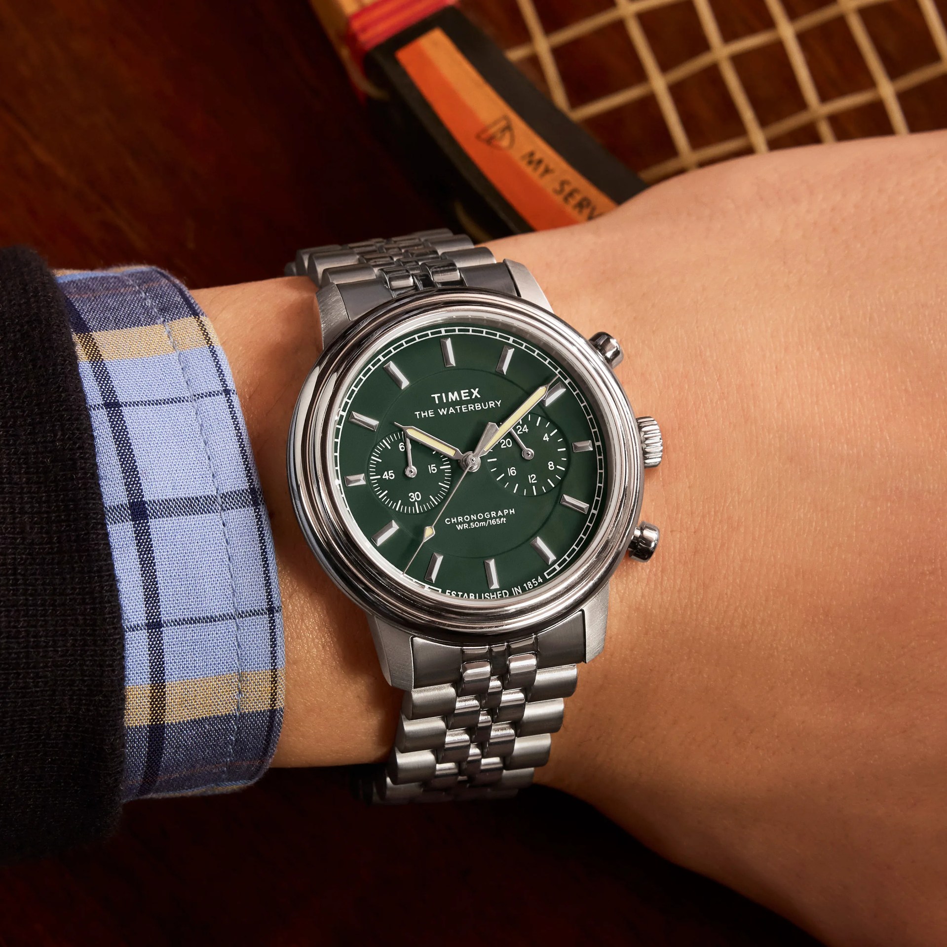 a Timex chronograph watch with a green dial on a man's wrist