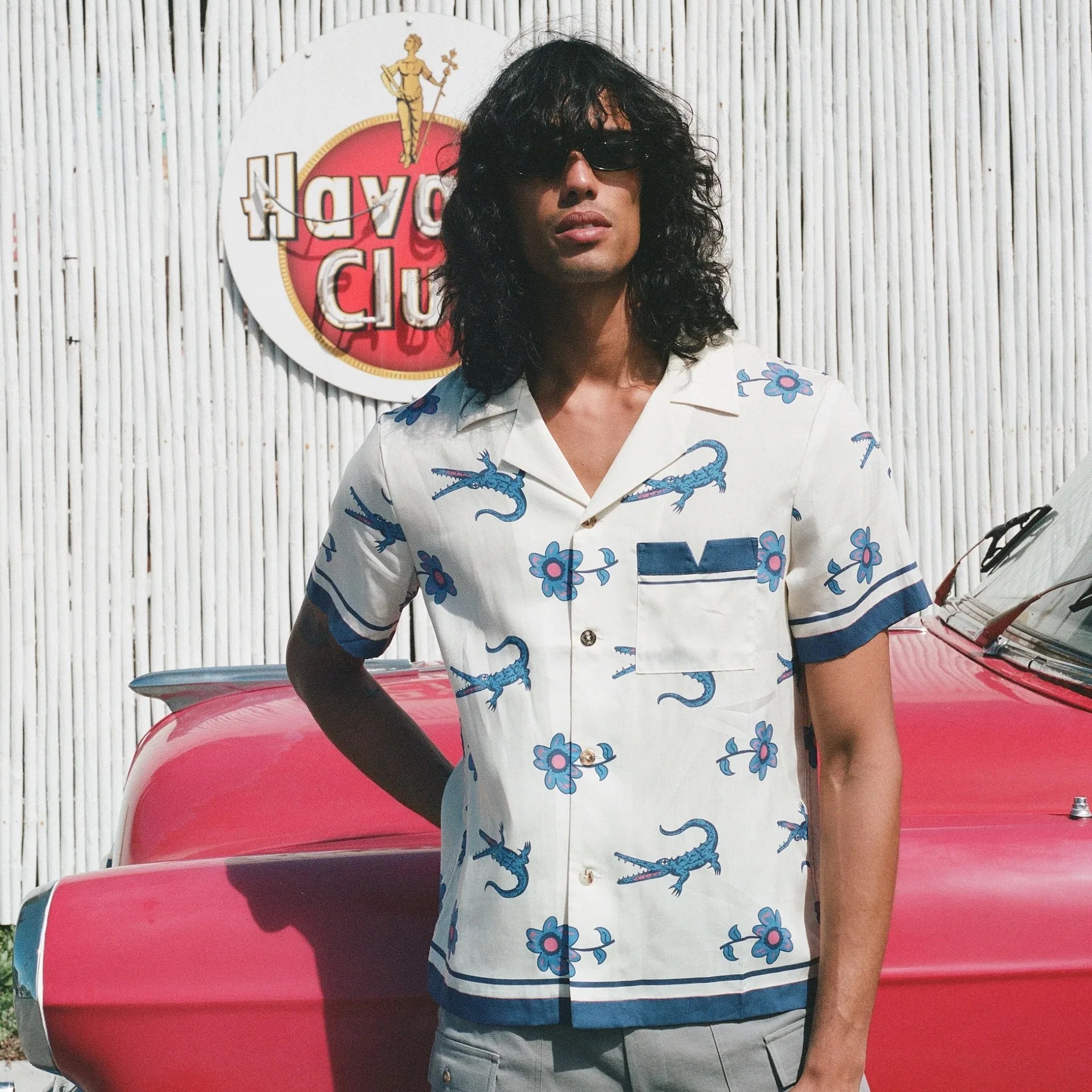 a man in a white shirt with flowers and crocodiles on it