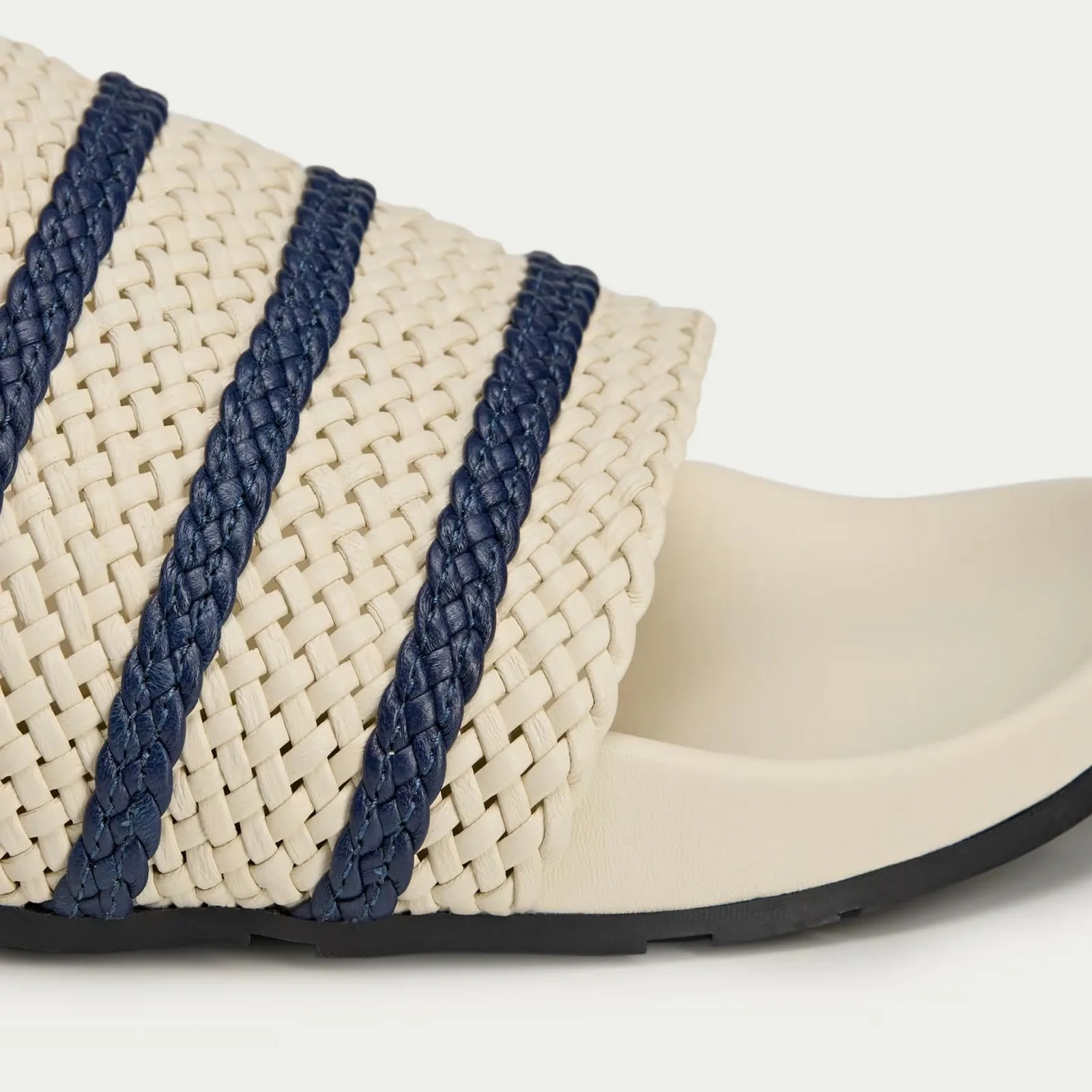 A detailed view showing the weaved upper of a Wales Bonner Adidas Adilette slides sandals in white.