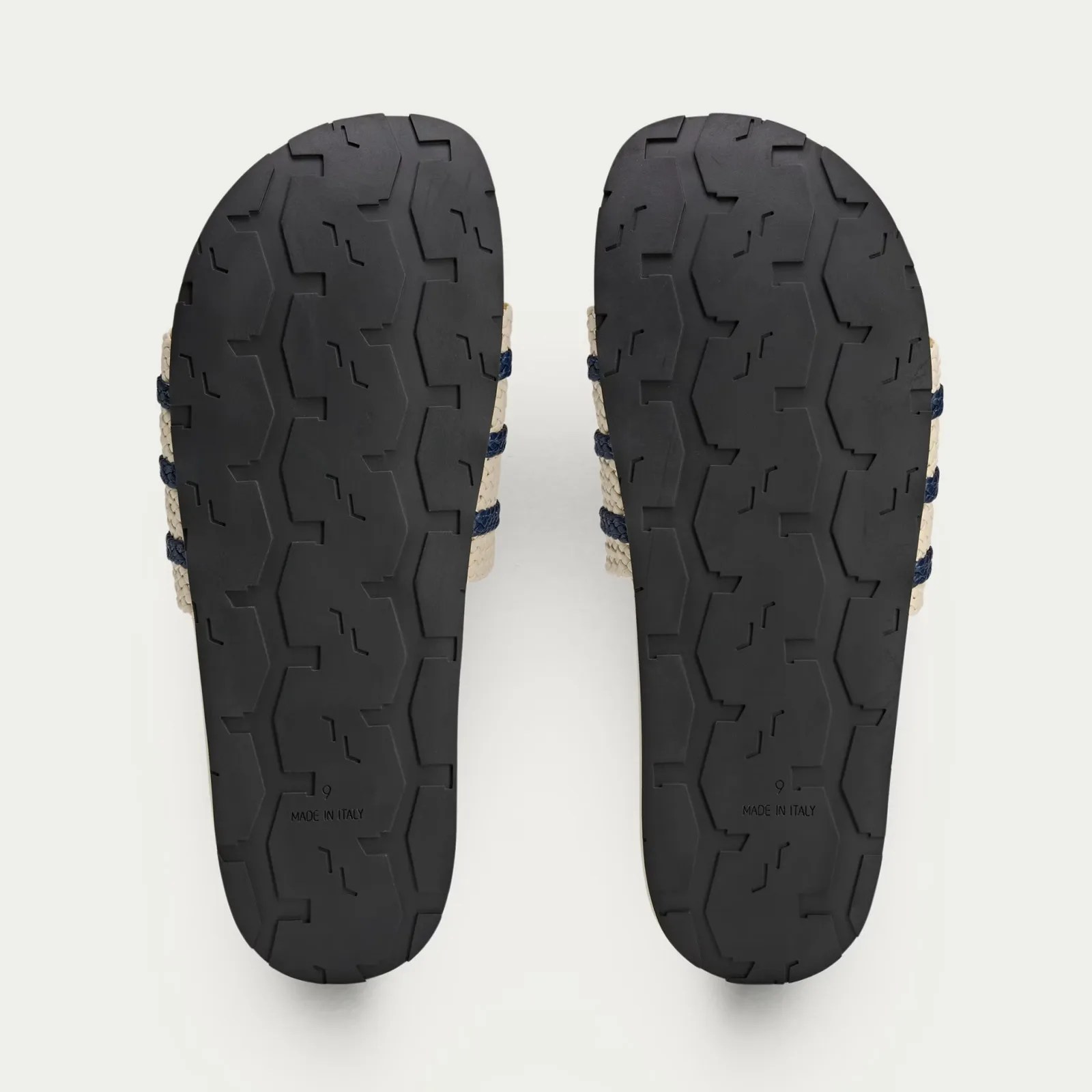 A pair of Wales Bonner Adidas Adilette slides sandals in white shown with the sandal soles facing up. 