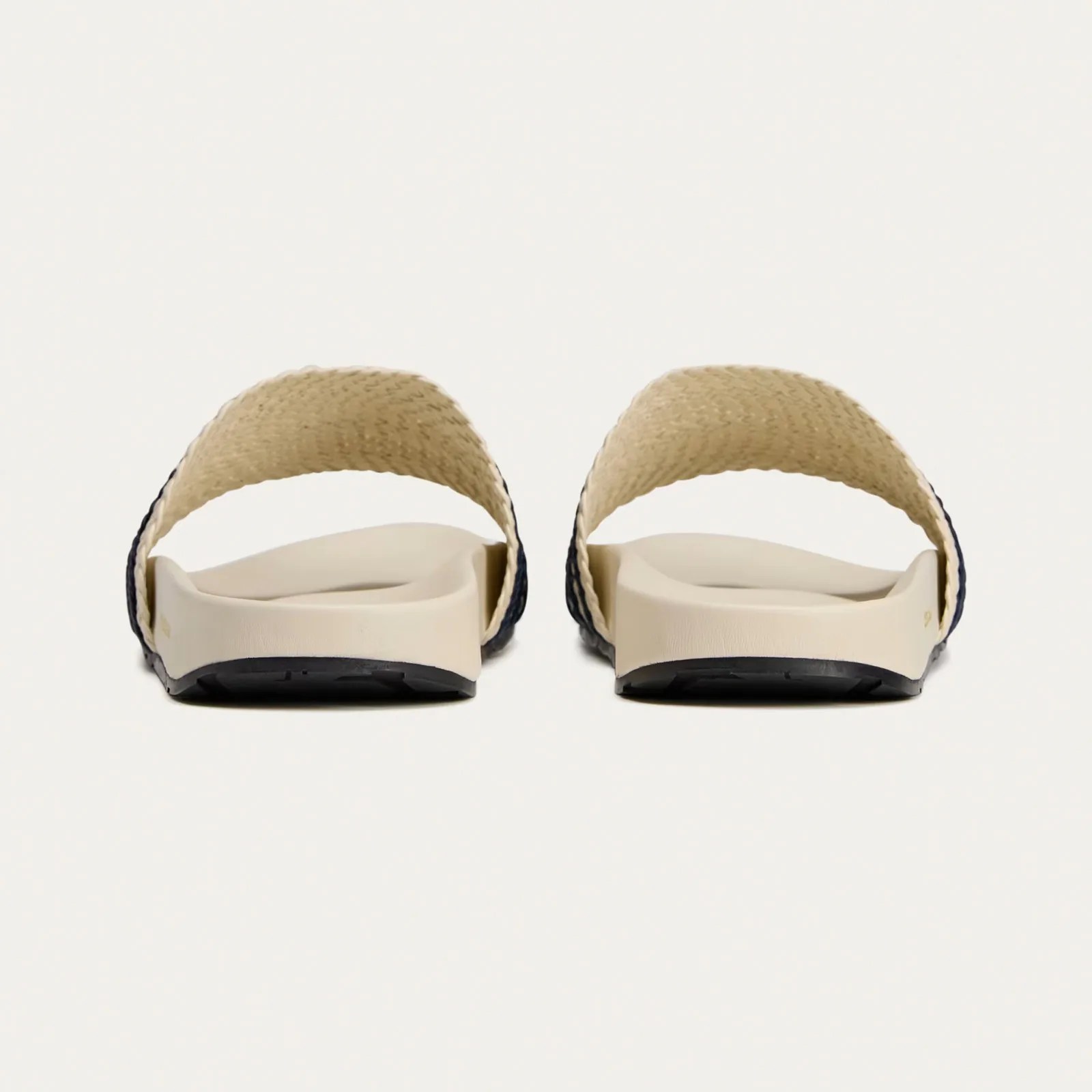 A pair of Wales Bonner Adidas Adilette slides sandals in white shown from the heel forward. 
