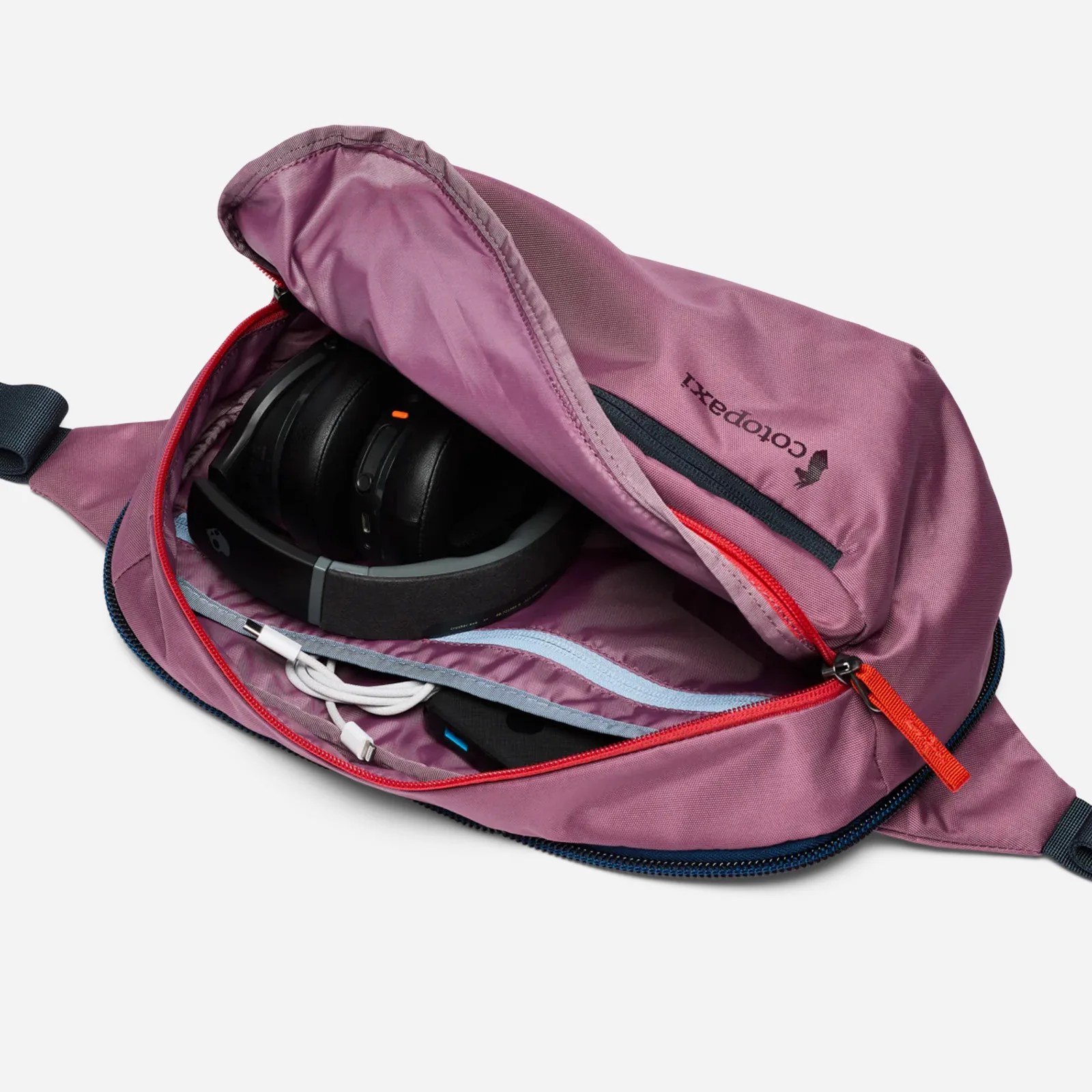 The Cotopaxi Allpa 50L Adventure Travel Pack's companion 8L sling bag shown open to reveal internal storage compartments and travel essentials stored inside. 