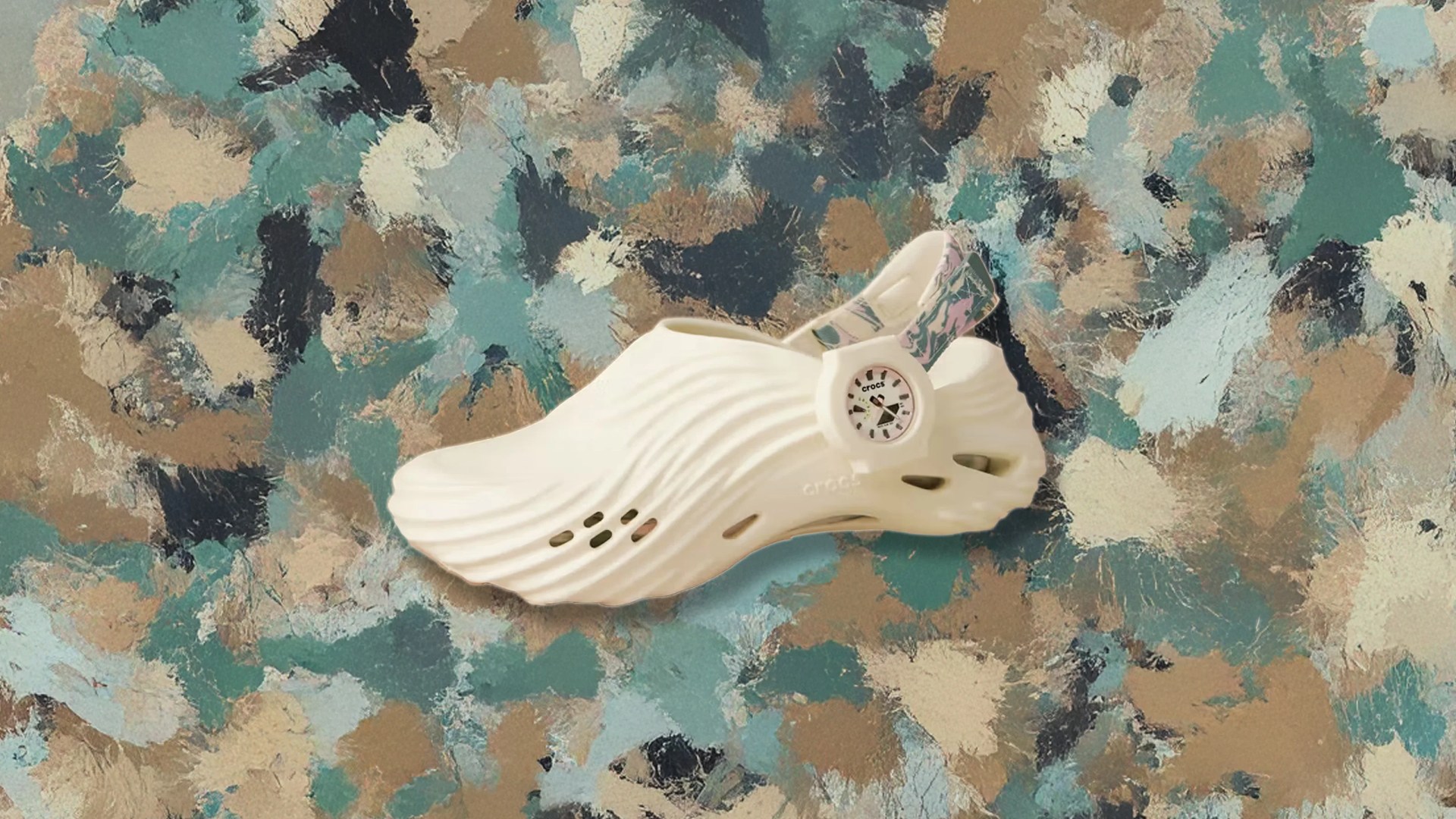 A Single Crocs Echo Wave shoe shown with the toe facing left against a splatted paint background of greens, tans, navies and greys.