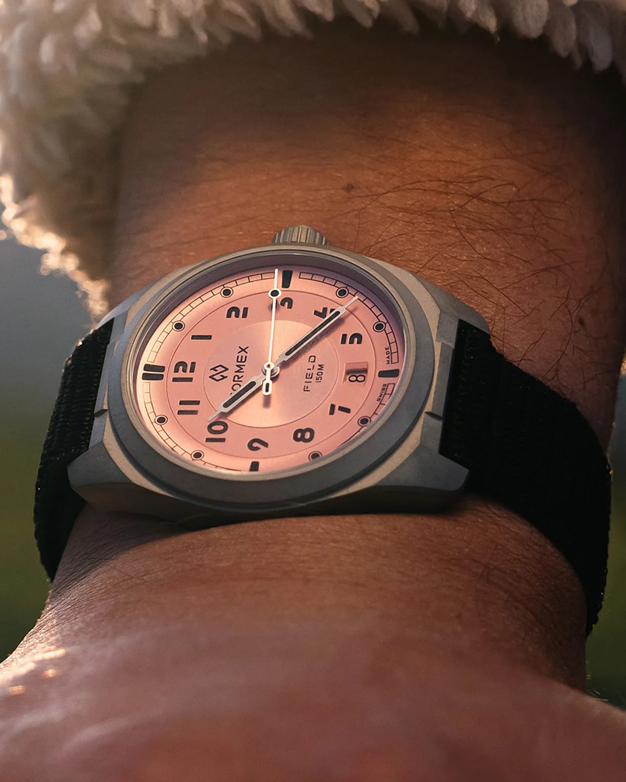 a pink dial Formex field watch on a man's wrist