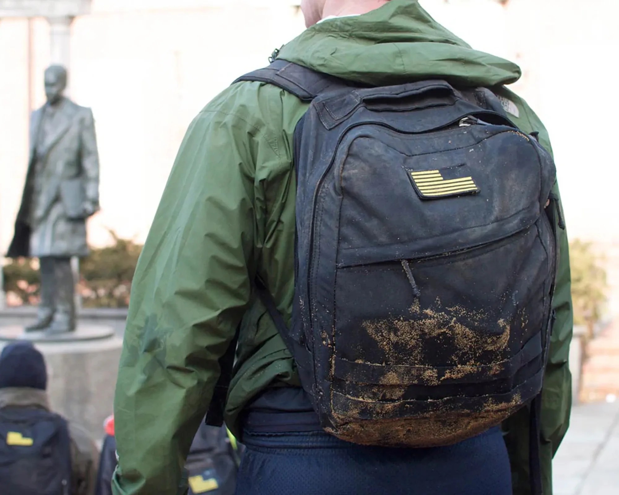 GoRuck backpack on back covered in mud