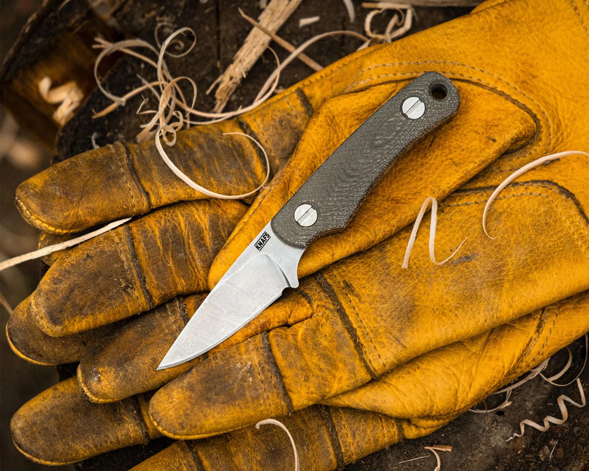 Knafs Little Lulu Knife on work gloves next to wood shavings