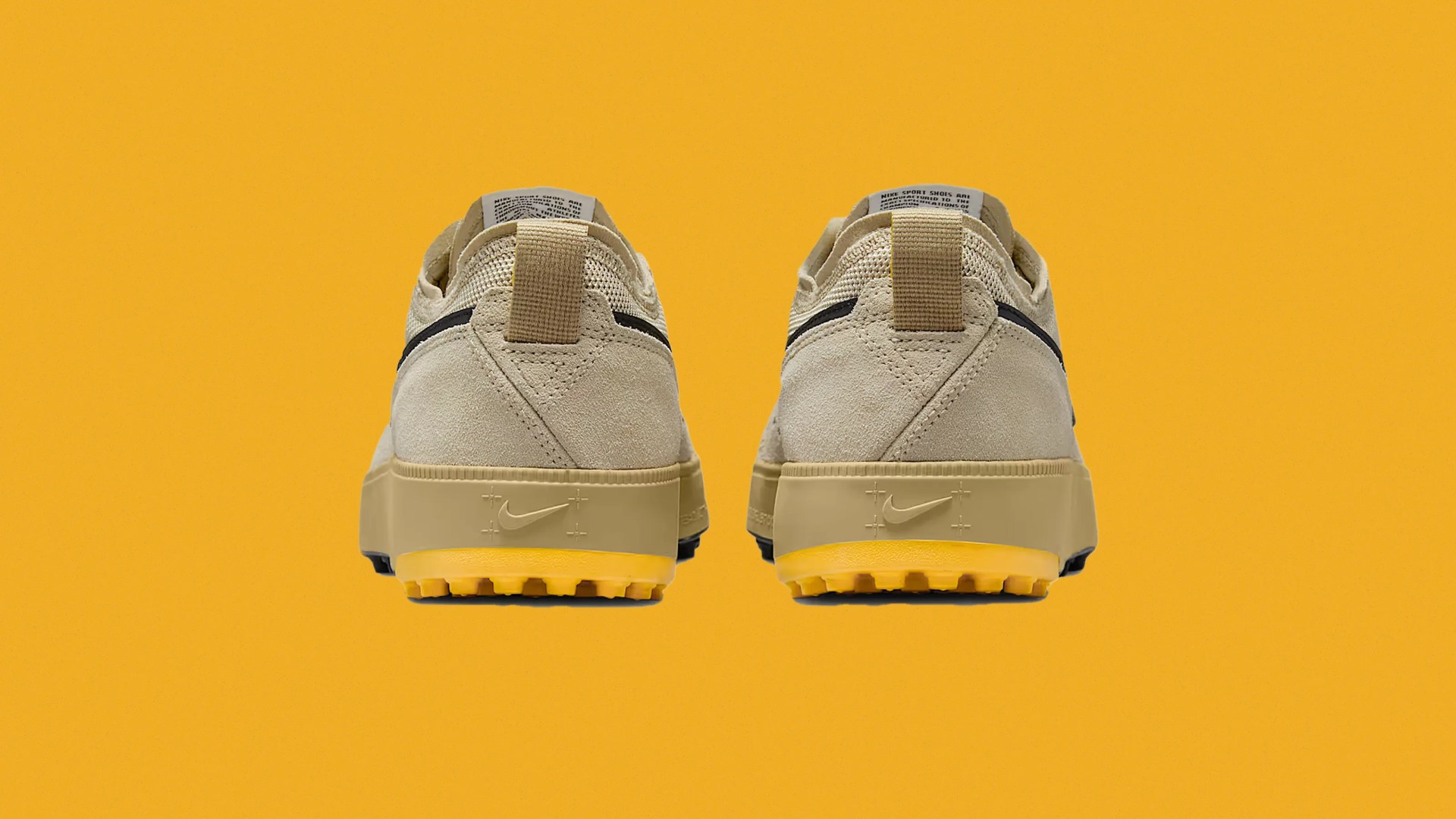 A pair of Nike C1ty sneakers sitting side by side shown from the heels against a bright yellow background