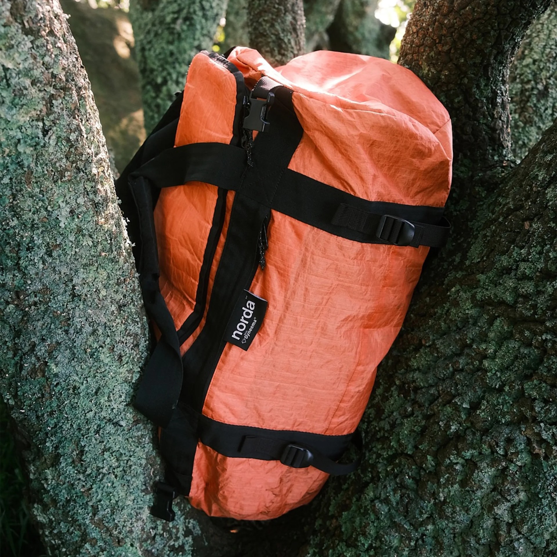 Norda Orange Toolbox Duffle Bag sitting on a tree