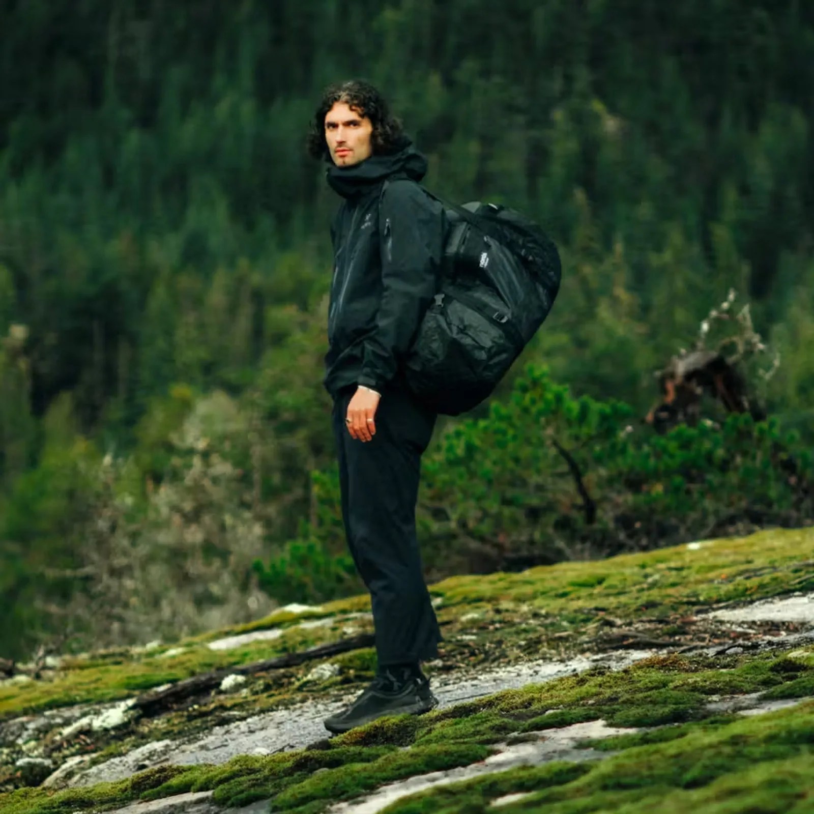 Norda Toolbox Dyneema Duffel Bag in Stealth black being worn on a man's back like a backpack. 