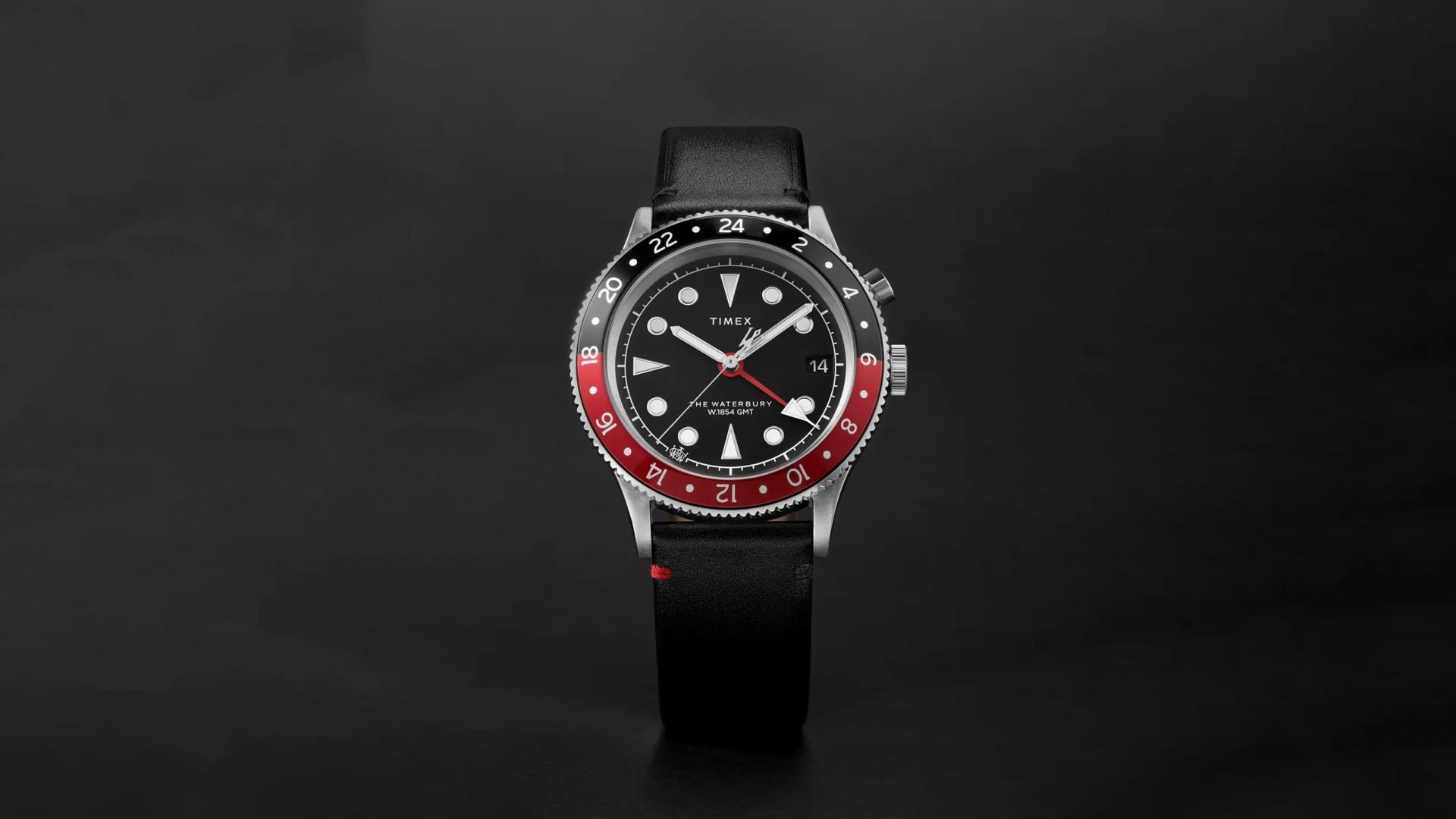 A Timex Waterbury Traditional GMT 39mm watch on a shadowy black background