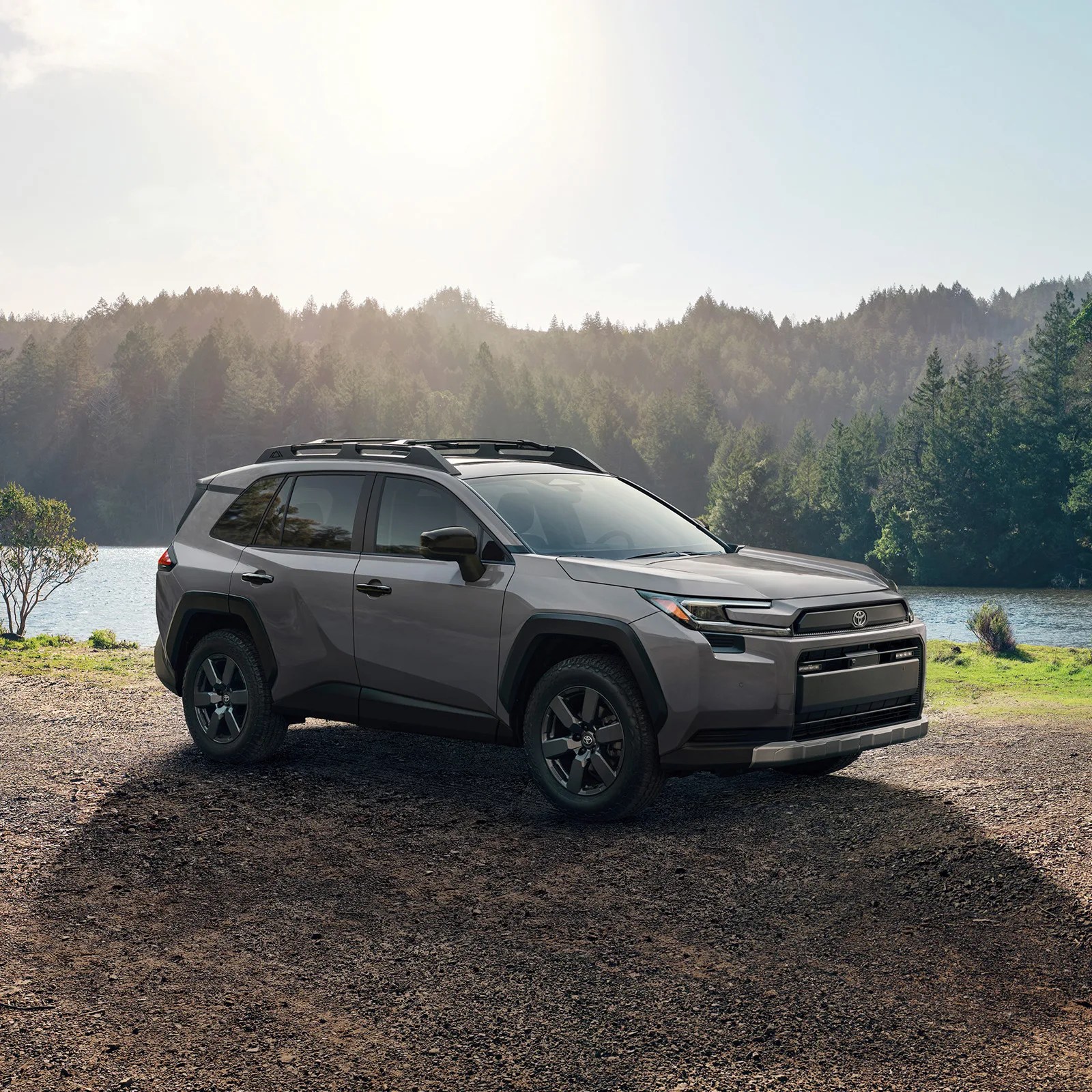 A 2026 Toyota RAV4 Woodland Edition shown parked in front of a lake with forest in the background. 
