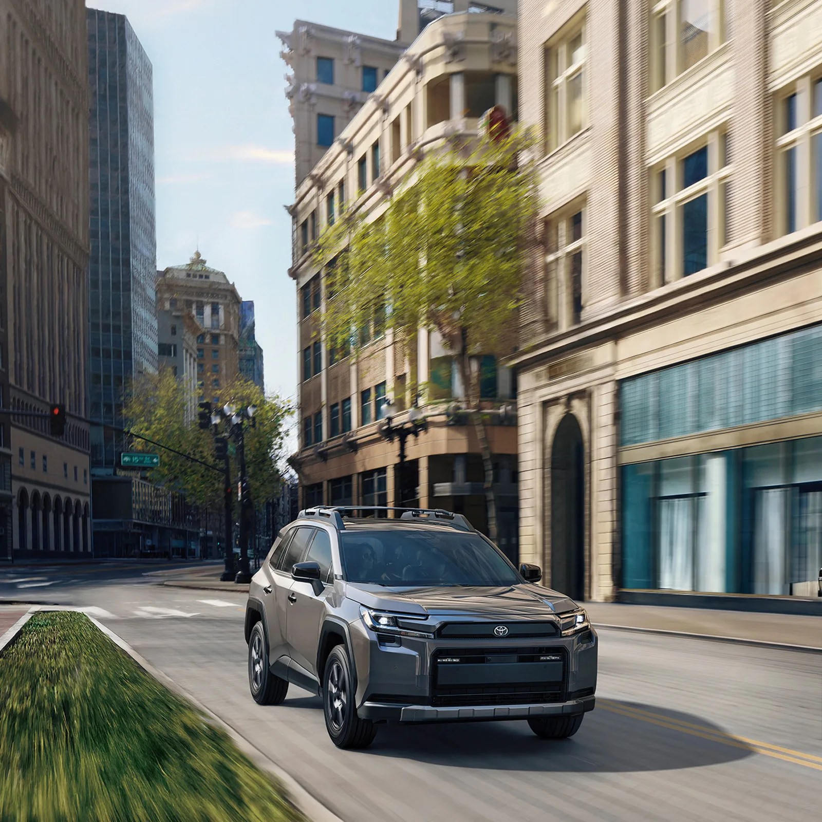 The 2026 Toyota RAV4 Woodland Edition shown driving down a city street. 