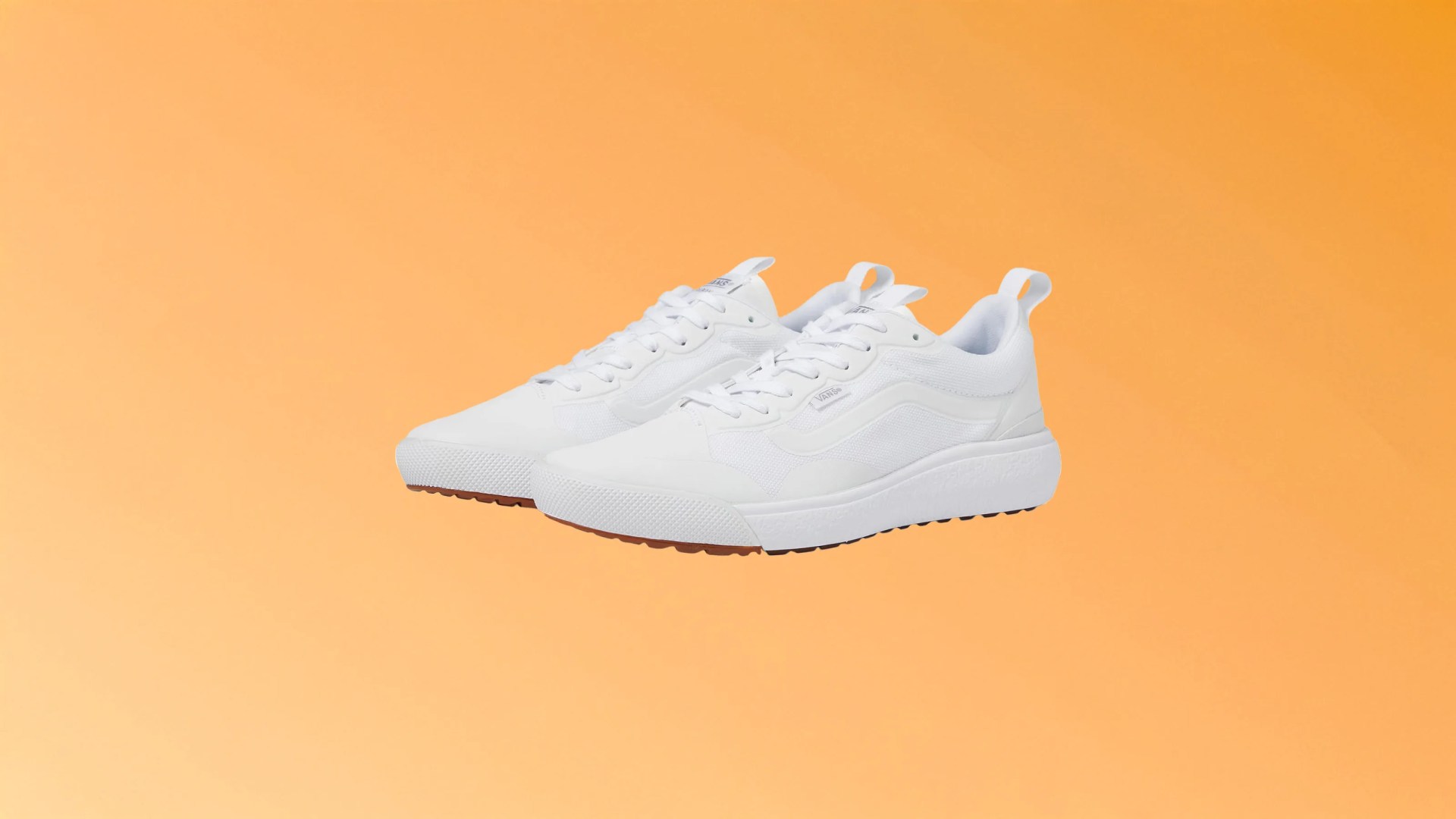 A pair of Vans UltraRange EXO shoes in white on top of a light sherbert orange background