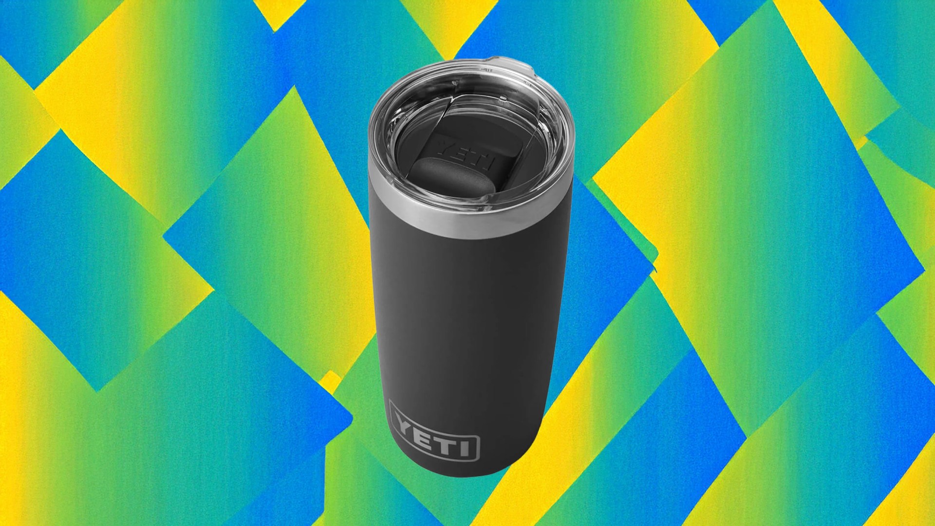 A Yeti 10oz Rambler in black shown against a bright blue, green and yellow background pattern