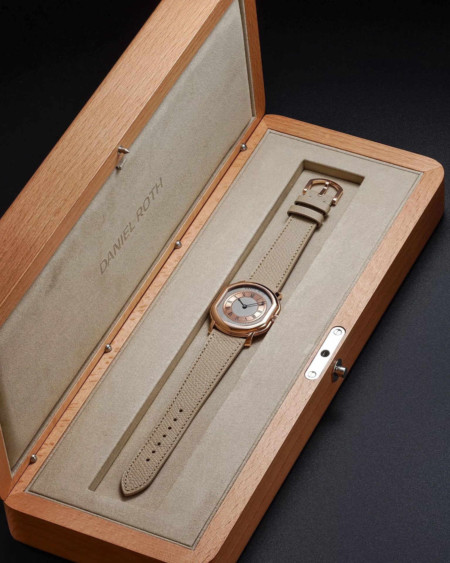 a gold Daniel Roth dress watch in its wooden case
