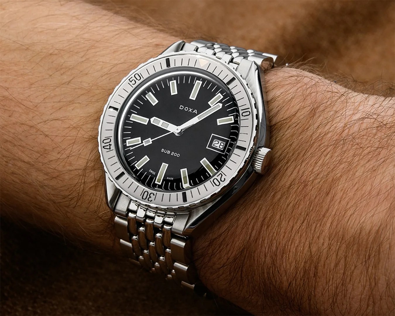 a black Doxa dive watch on a man's wrist