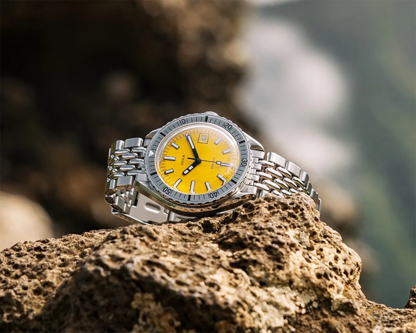 a yellow dive watch on a rock