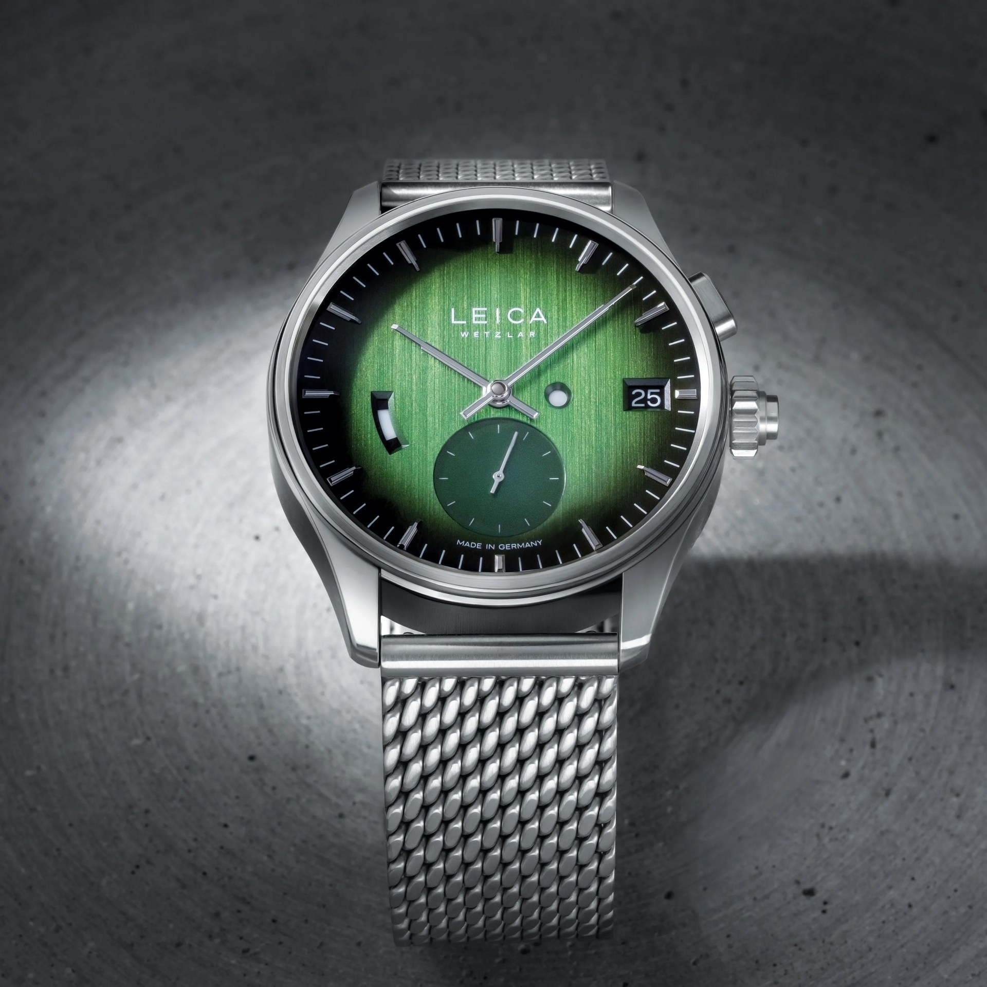 a steel watch with a green dial