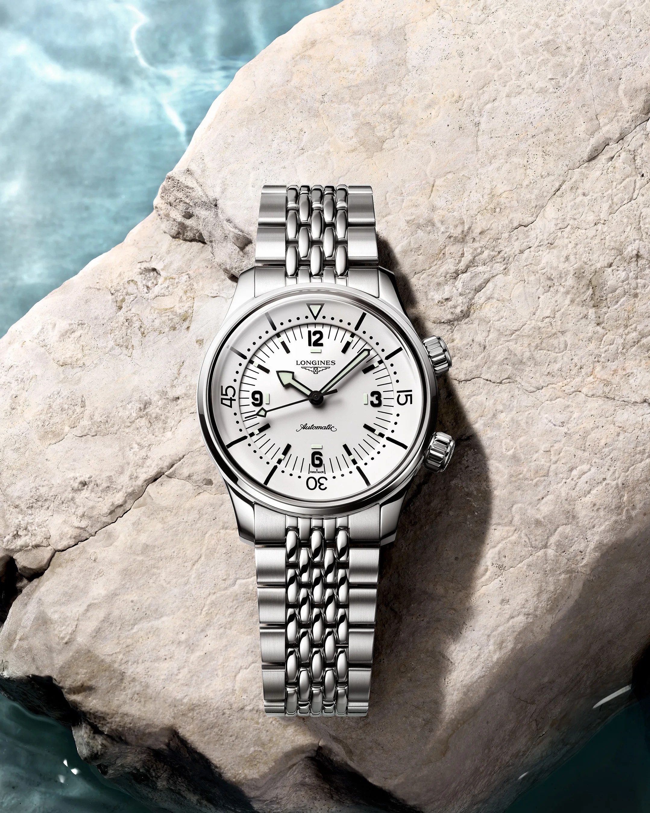 a Longines dive watch on a rock