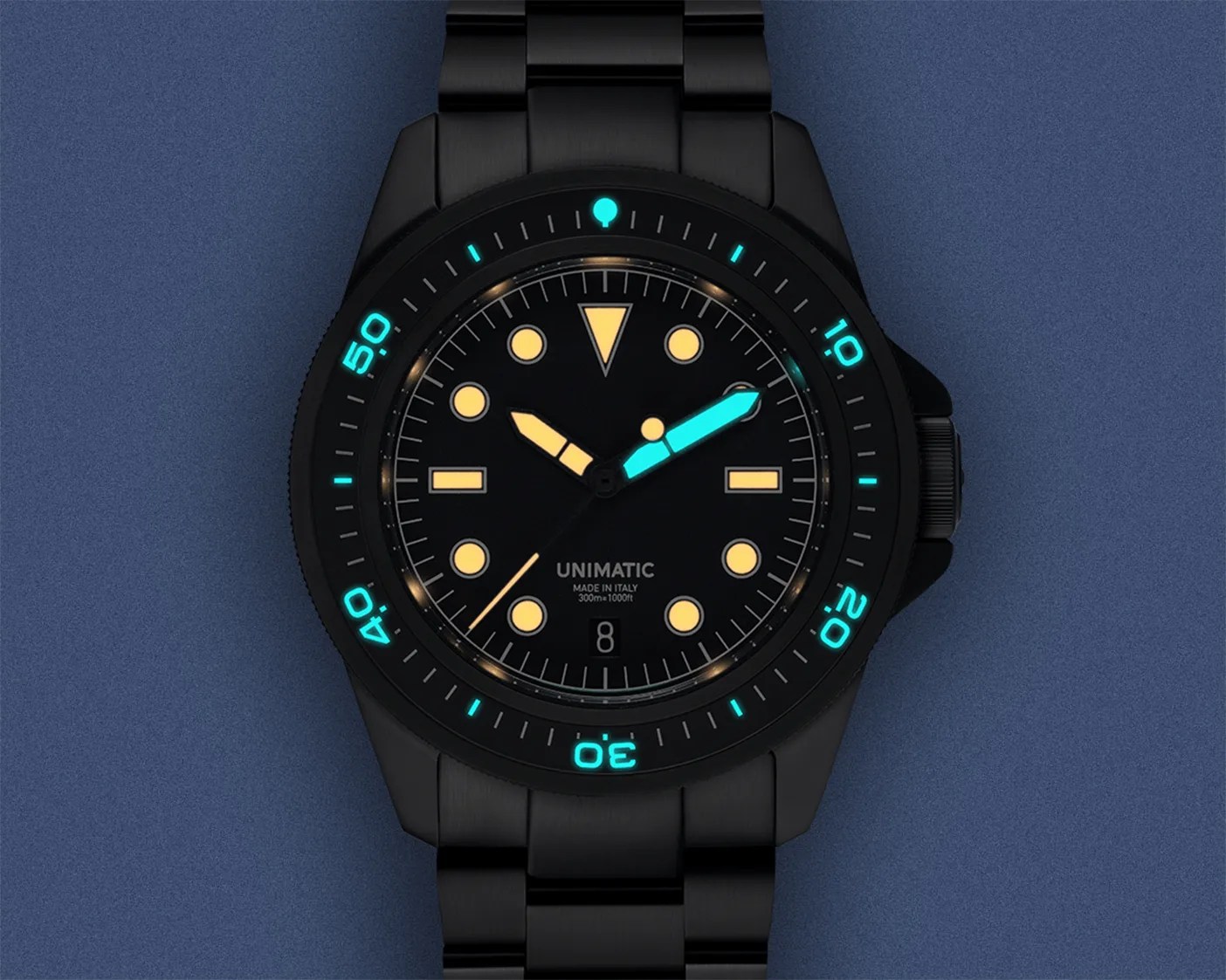 lume glowing on a black Unimatic dive watch