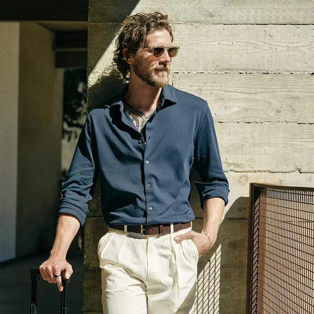 a man in a navy blue shirt and cream chinos