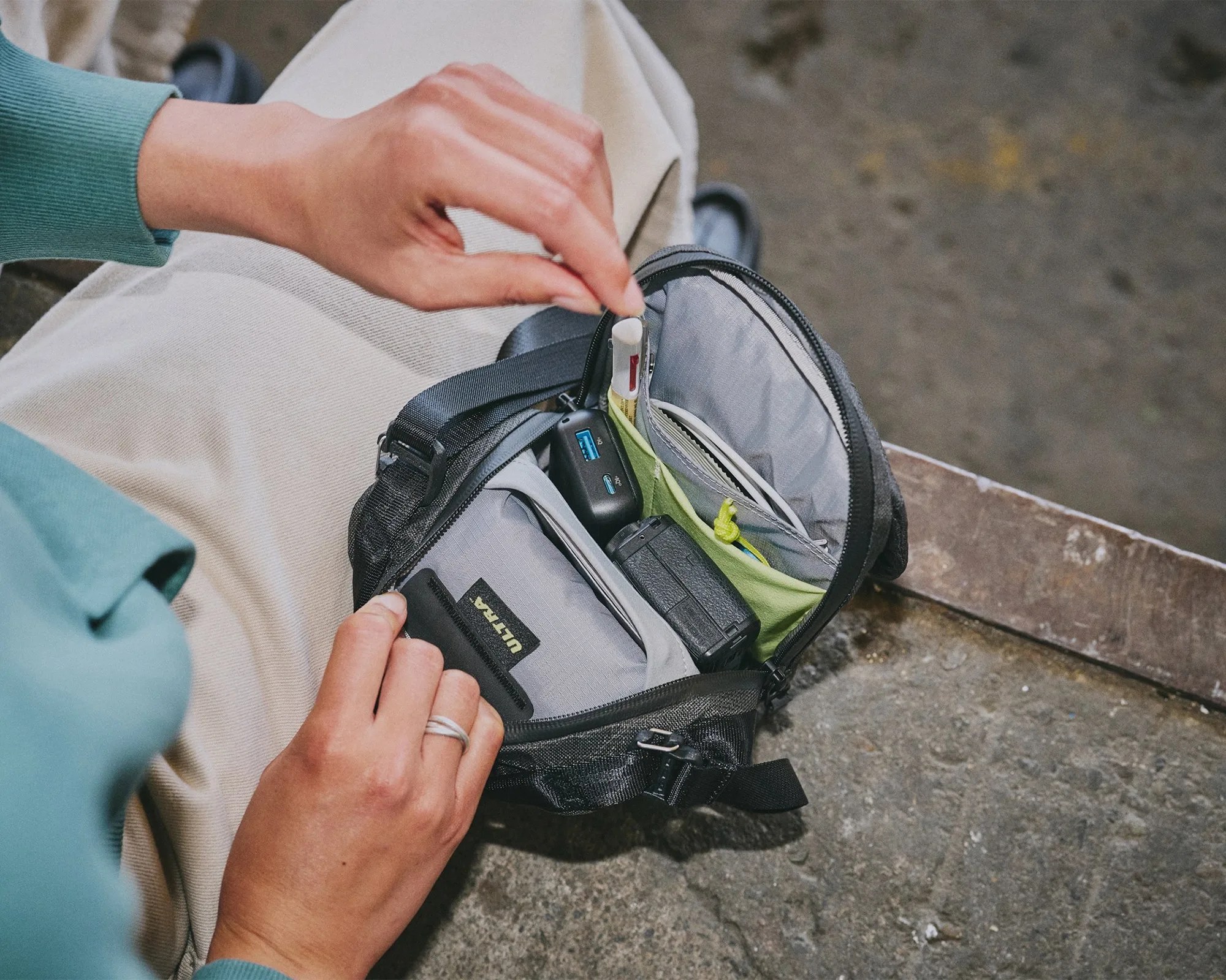 Aer Street Sling EDC Crossbody Pack open showing interior on city street