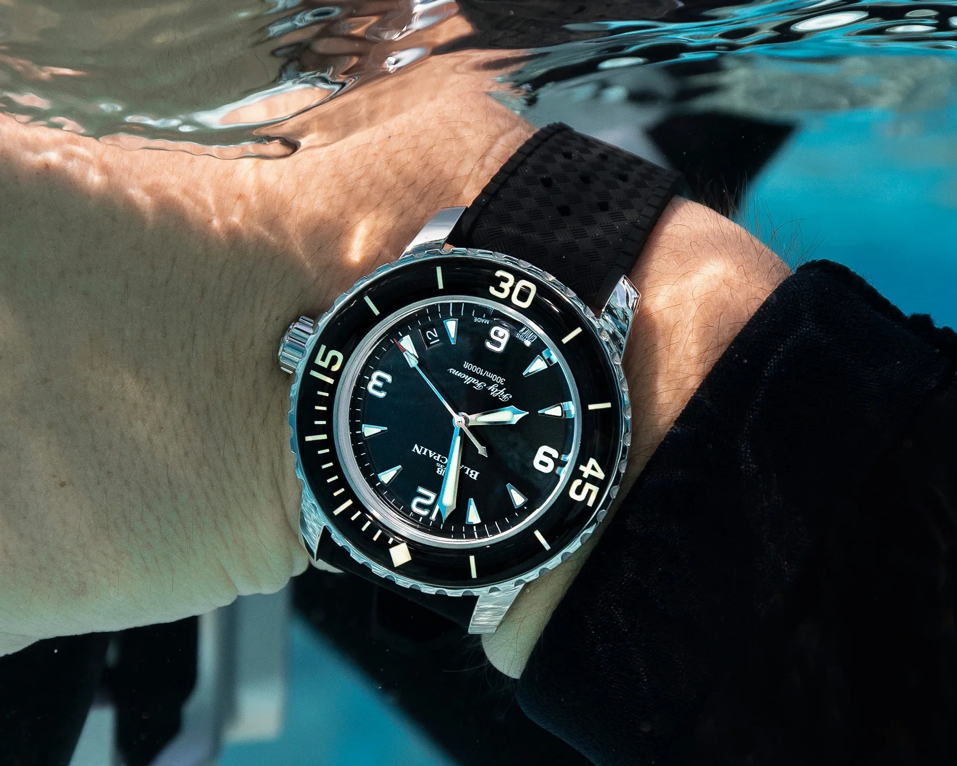 a black dive watch on a diver's wrist
