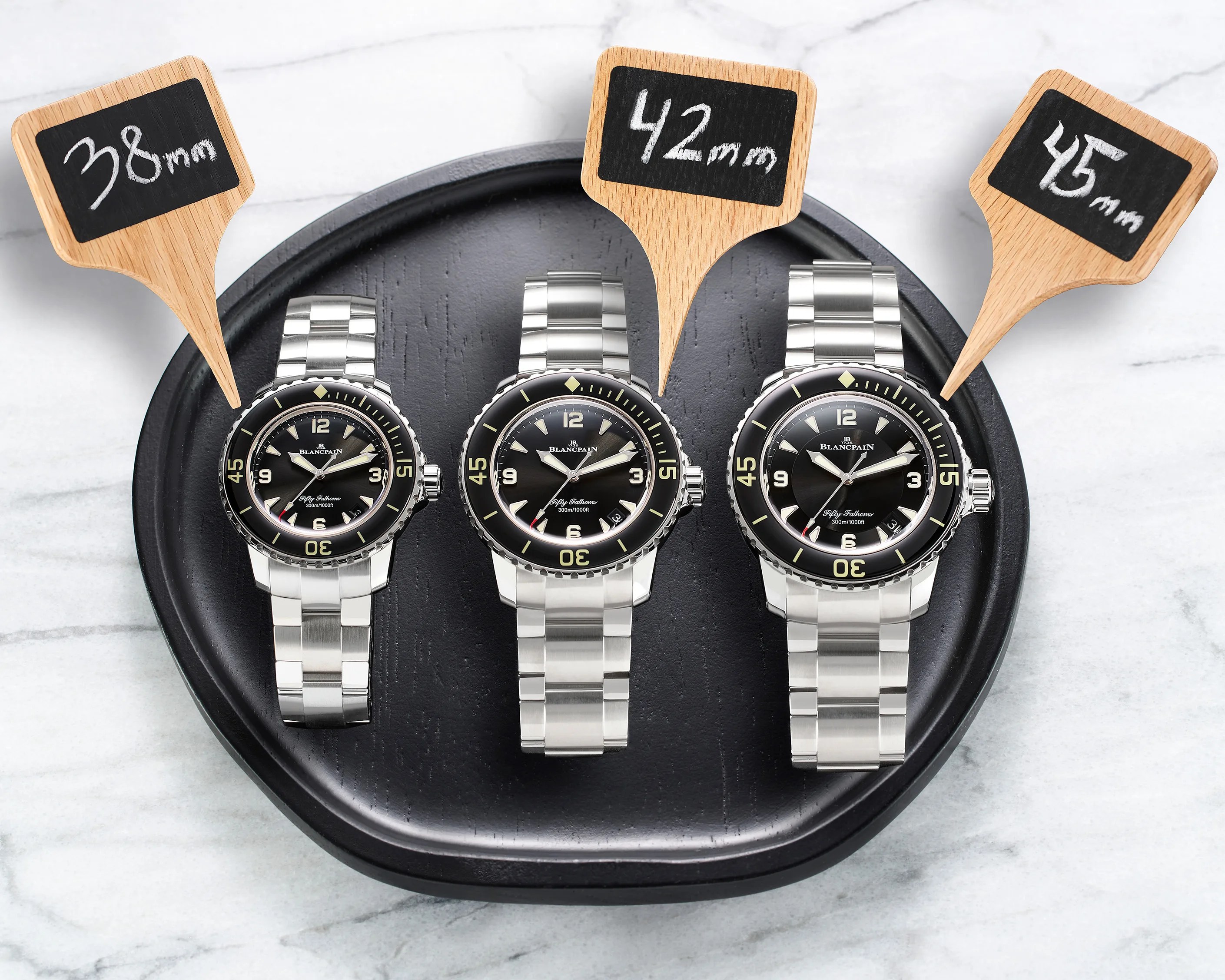 three dive watches of different sizes on a tray together