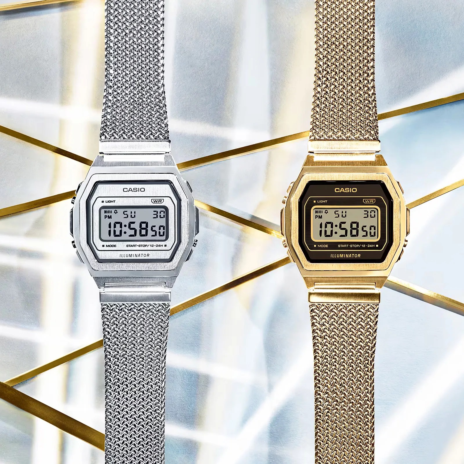 Two Casio A1000MA-7VT watches in gold and silver shown lying flat against a patterned background
