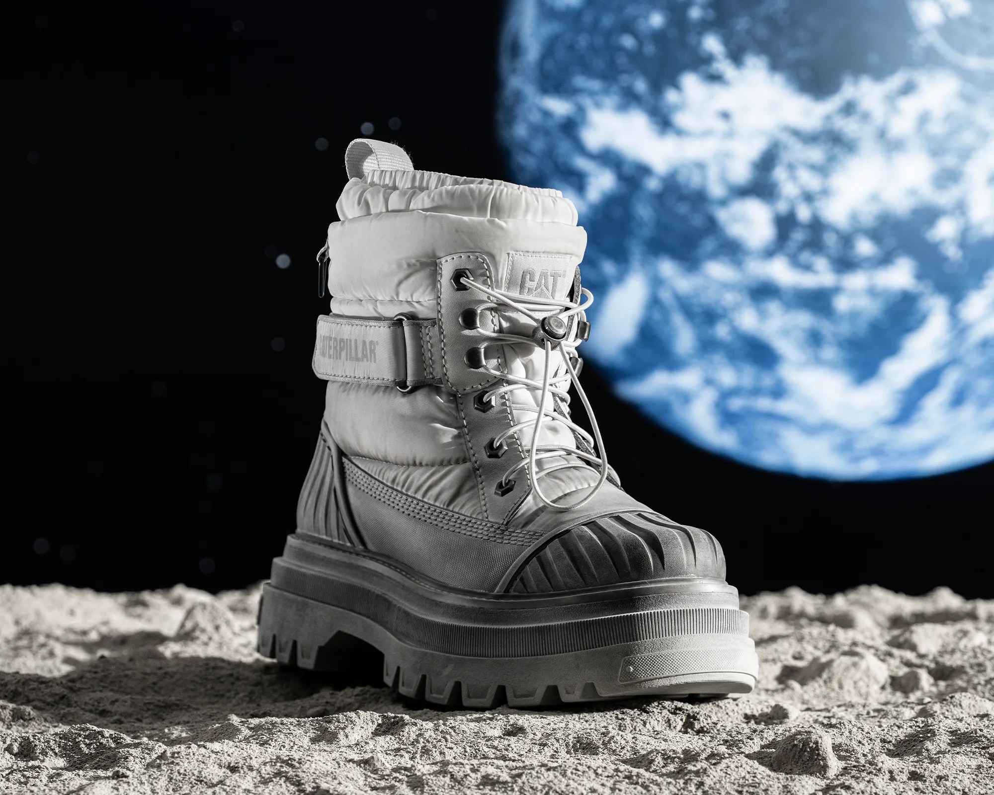 Cat Footwear Centennial Apollo 11 Boot on the lunar surface with Earth in the background