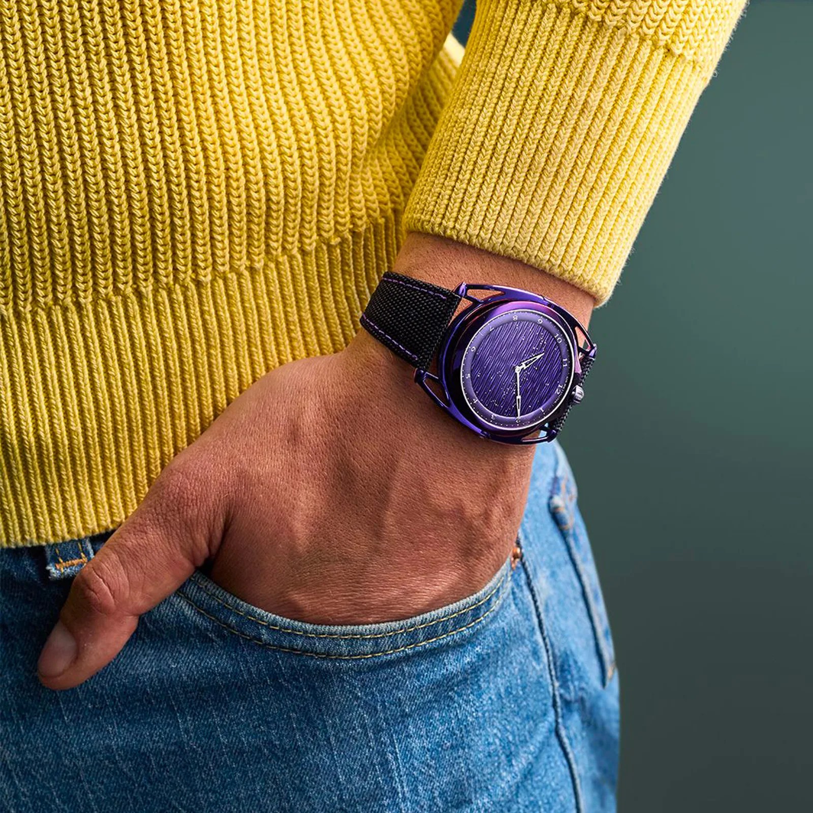 The De Bethune Db28xs Purple Rain worn on the wrist of a model wearing a yellow sweater and blue jeans