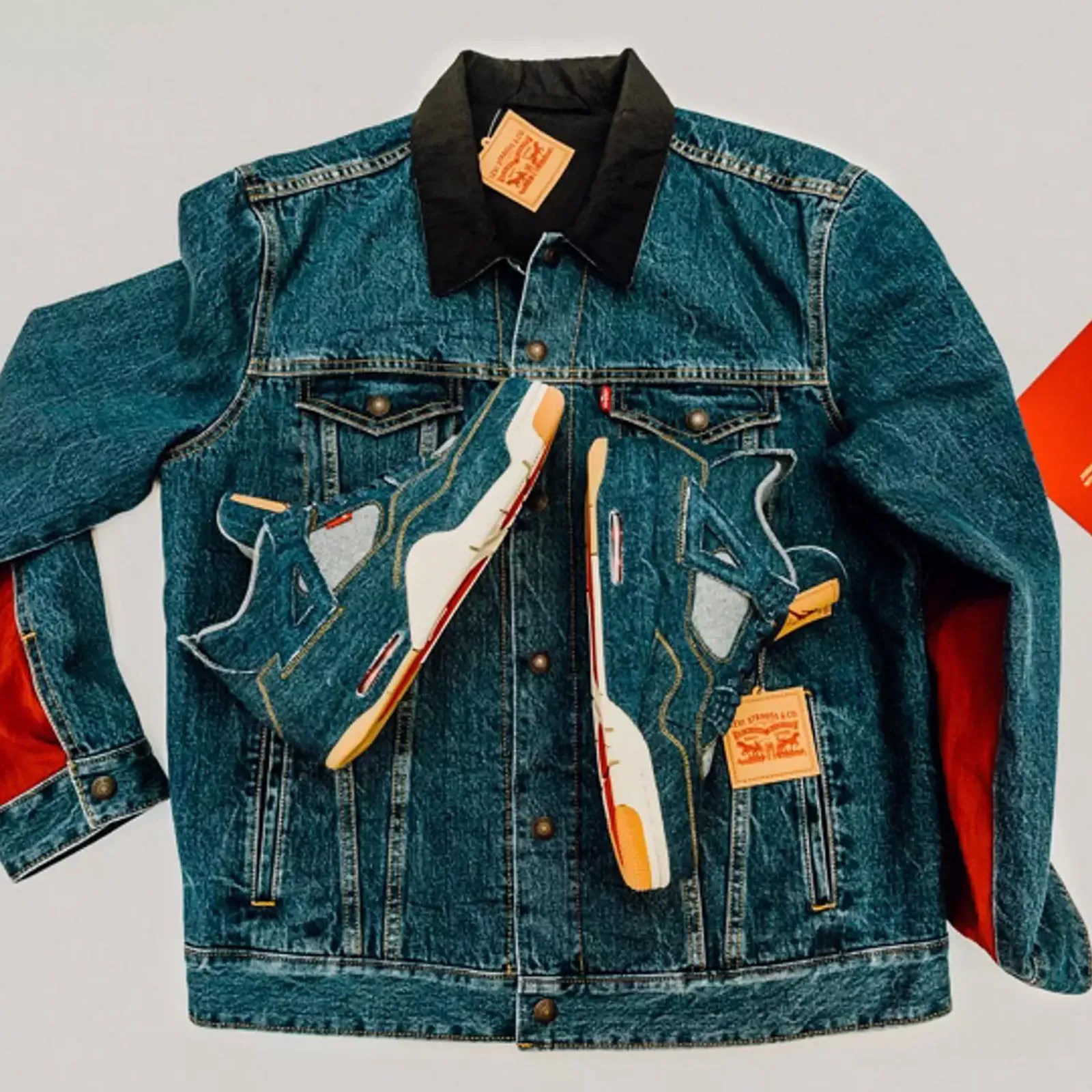 A Levi's x Jordan Brand reversible denim trucker jacket with a pair of Levi's x Jordan IVs sneakers sitting on top.